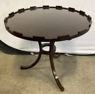 BAKER Vintage Round Wooden Guerdion Side Table: BAKER Vintage Round Wooden Guerdion Side Table. The table features a smooth, round tabletop with a notched or crenelated edge and a distinctive three leg base. Rich brown hued finish. Underside reads