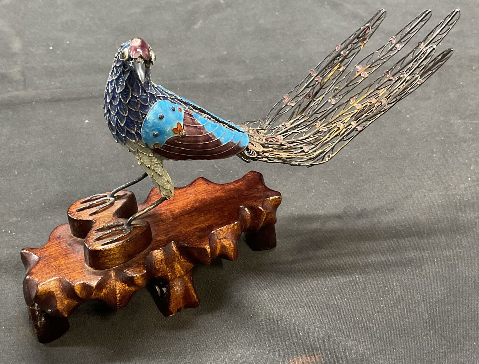 Vtg Cloisonne Enamel Bird Figural on Wood Stand: Vintage handmade cloisonne enameled metal filigree bird figural on wooden stand. Hues of blue and purple. Measures approx 6.5 x 1.5 x 4 inches. Wear including loss to enamel and warping. Cloisonne bir