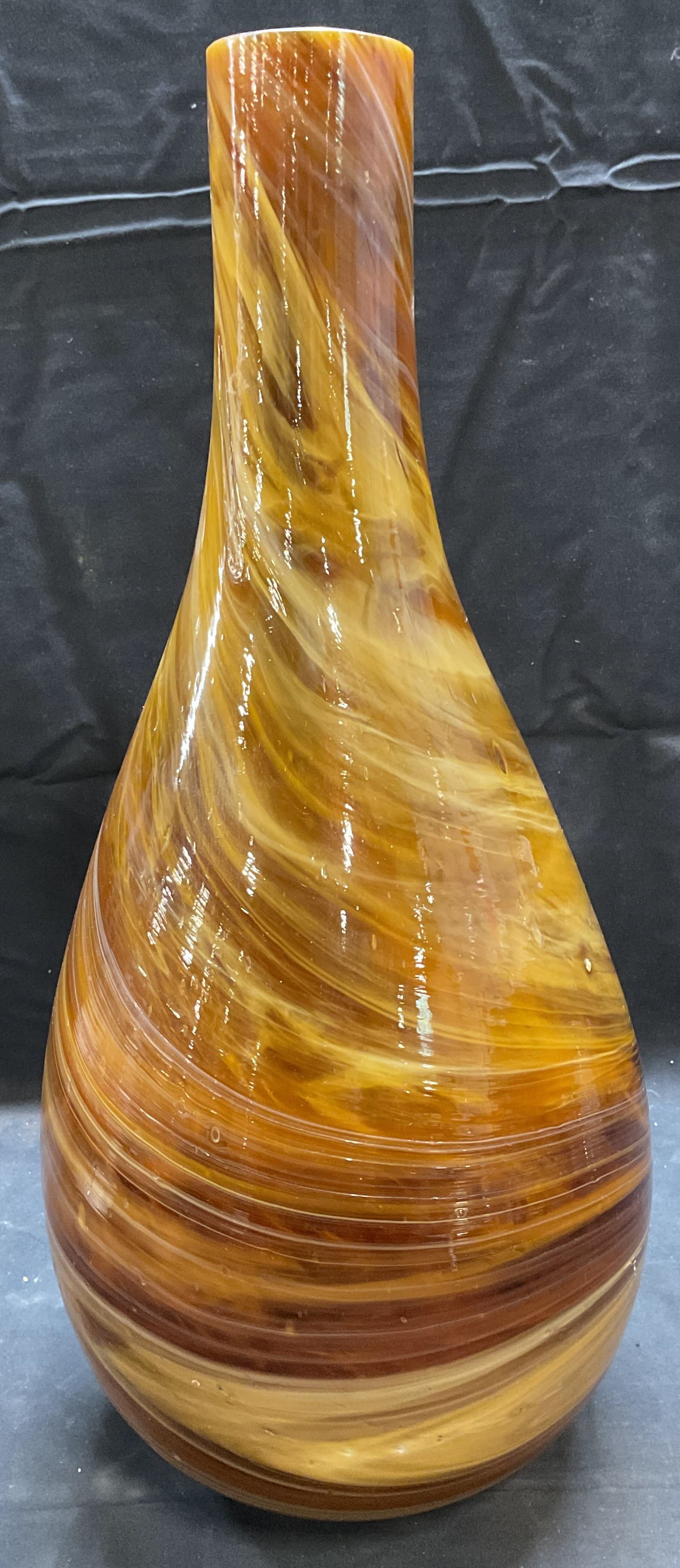 Tozai Hand Blown Amber Art Glass Teardrop Vase: Tozai hand blown amber art glass vase. Swirl pattern with teardrop shape. Thick walled glass, piece has weight. Signed on underside. Measures approx 7 x 17 inches. Some wear including scratching obser