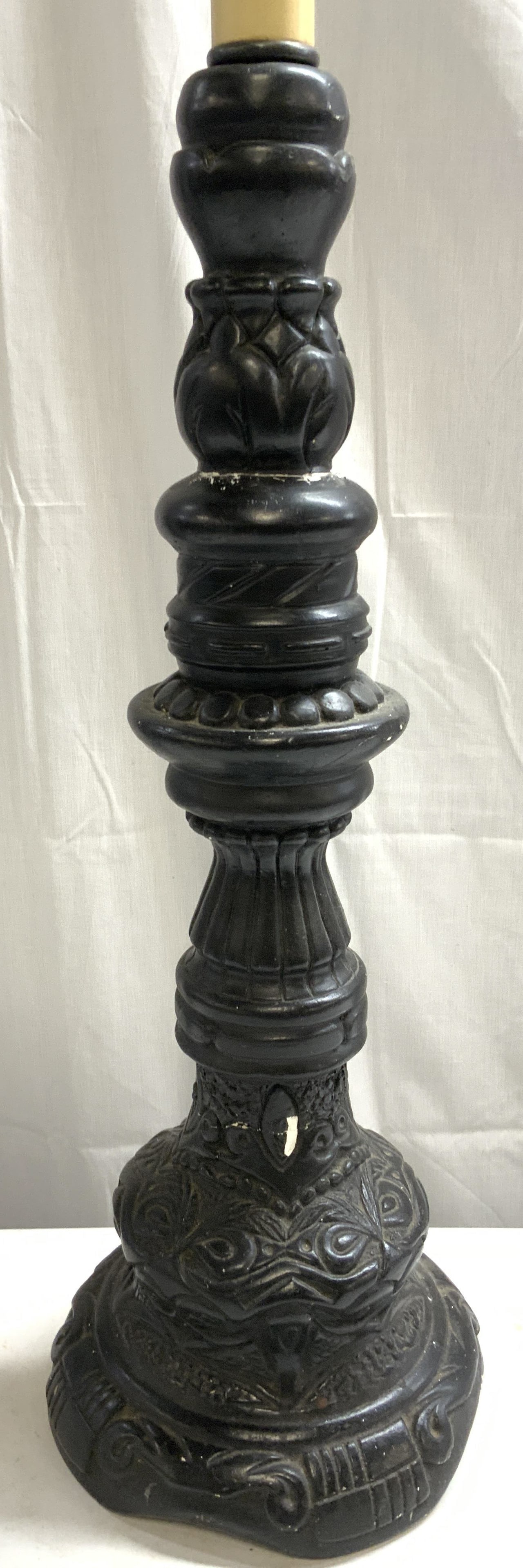 Vintage Plaster Side Table Lamp: Lamp is vintage. Piece is plaster with black toned finish. Lamp has intricate relief detail. Lamp includes harp. Piece has black toned twist switch. Lamp measures approx 39.5 inches tall 8 inches wide
