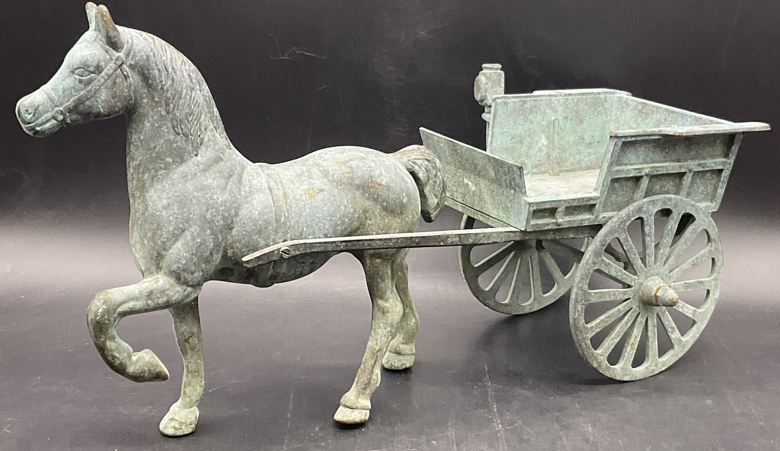 Bronze Horse W/ Articulated Carriage Statue: Bronze Horse W/ Articulated Carriage Statue. The wheels on the wagon / carriage are articulated. Piece measures approx. 8.5H x 15D x 5W in. Crafted from metal, appears to be bronze. Patina to the piec