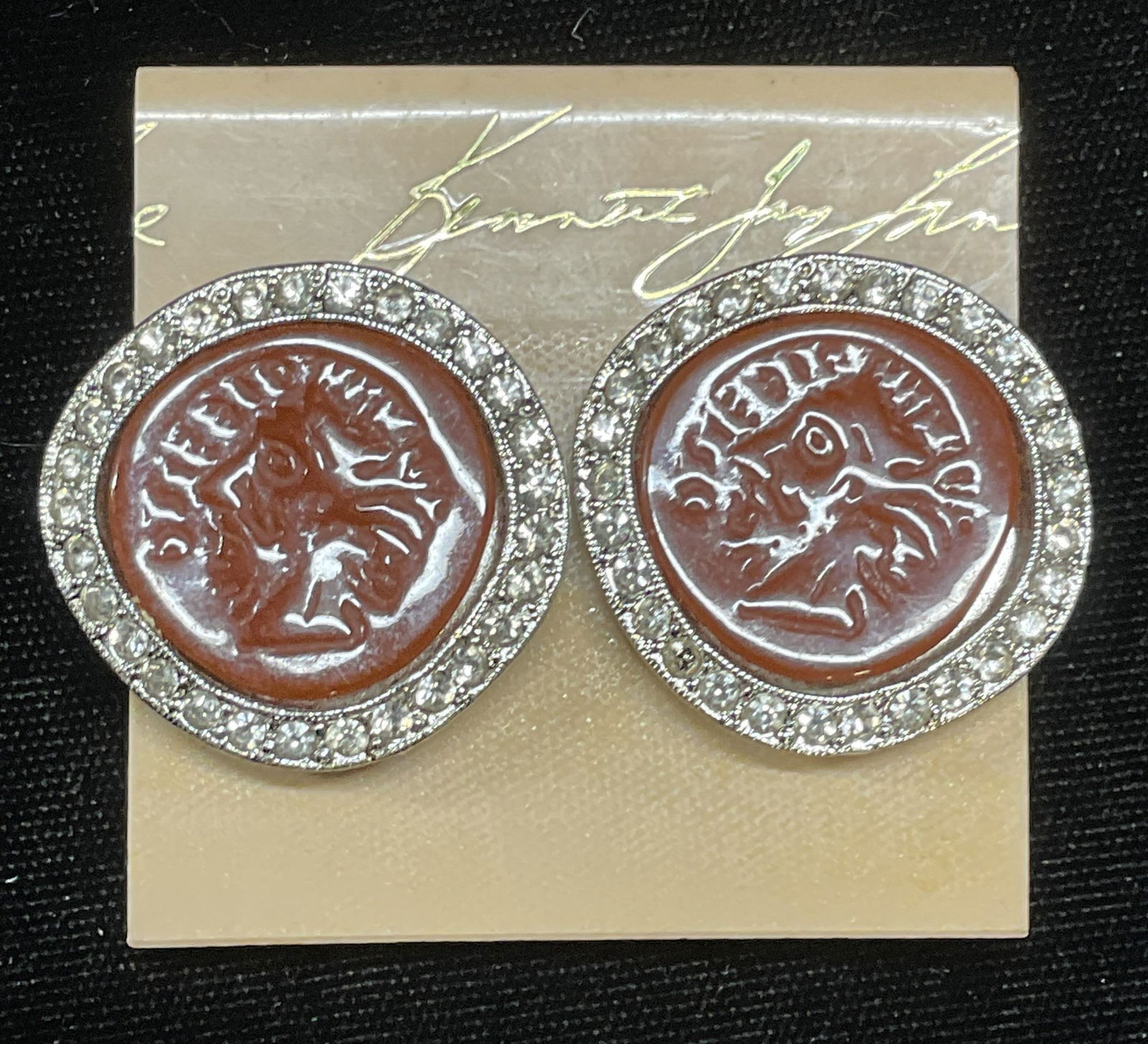 Vtg Kenneth Lane Coin Motif Crystal Earrings: Vintage Kenneth Jay Lane coin motif earrings. Silver tone, colorless crystal, lucite. Signed on underside. Measure approx 1.25 inches wide. Some scratching observed. Jewelry, estate jewelry, costume j