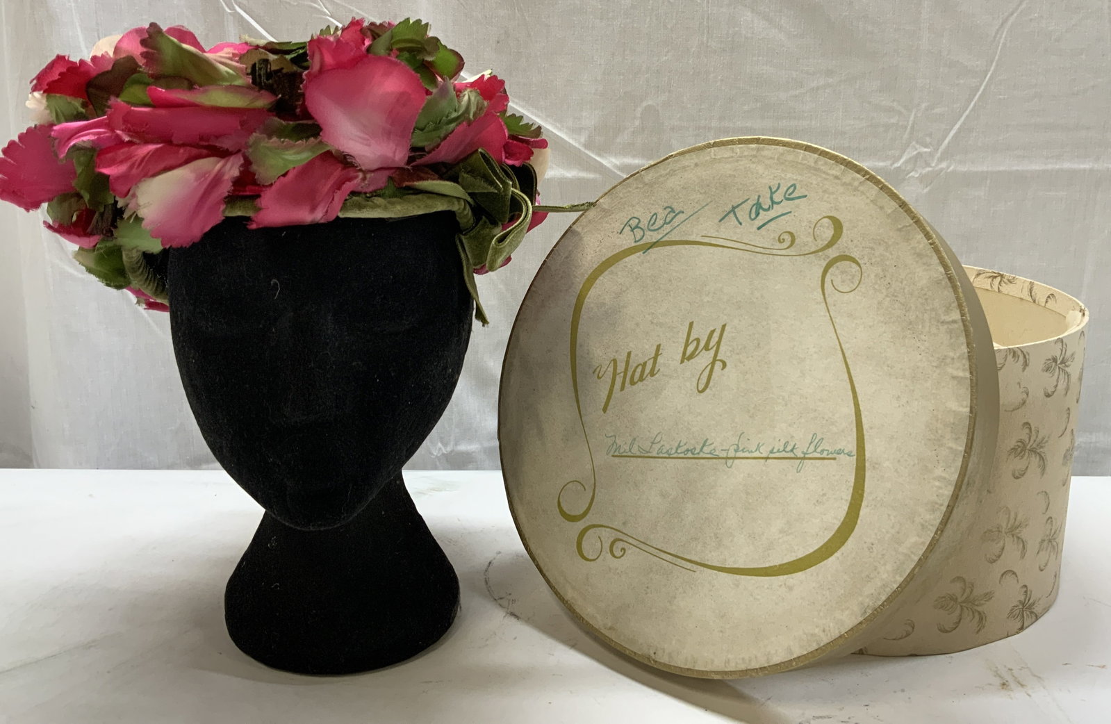 Vntg Milas New York Floral Hat w Round Box: Vntg Milas New York Floral Hat w Round Box Round hat that has pink & green pedals. Green ribbon in the front. Signed & marked by MILAS NEW YORK. Comes with round cream box. Surface wear consistent wit