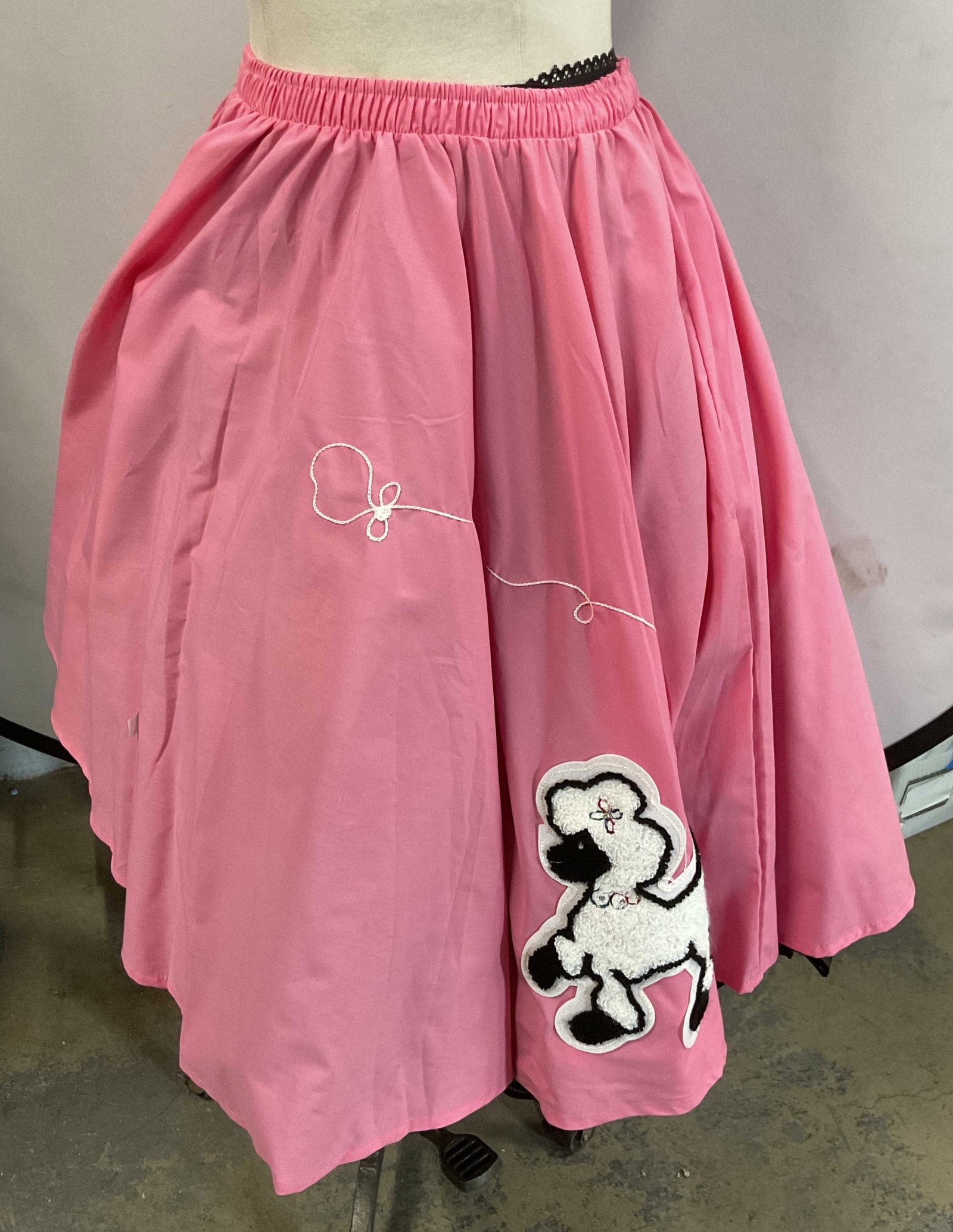 Cruisin USA Pink Poodle Skirt & Petticoat NWT: Cruisin USA pink poodle skirt. New with tag. Cotton blend. Embroidered poodle applique. Elastic waist, measures approx 13.5 inches across waist, 27.5 inches long. Includes Malco Modes black crinoline 