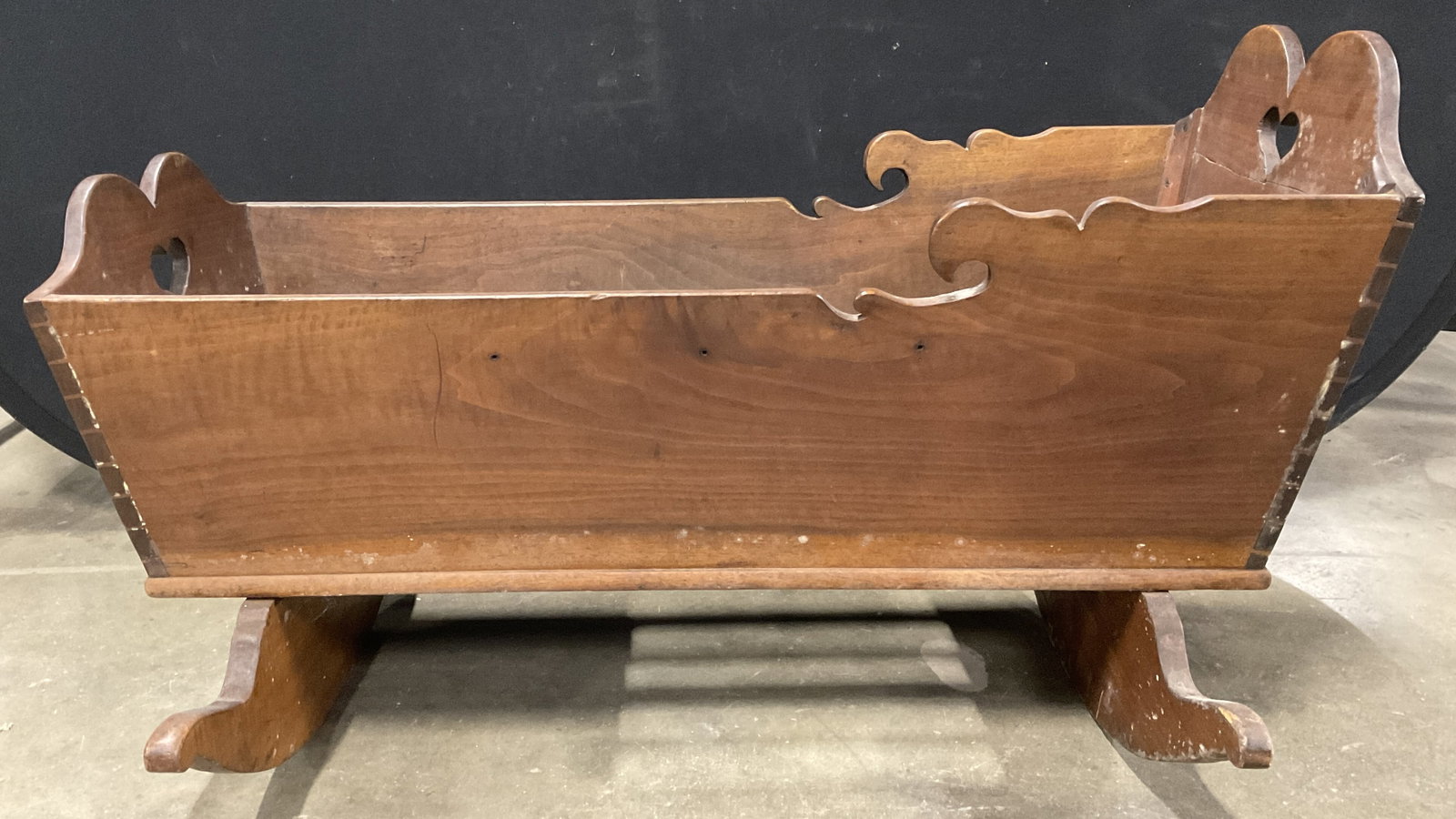Antique Wooden Heart Motif Cradle: Antique, possibly vintage. Wooden Heart Motif Cradle. Measures approx. 22.5H x 39.25W x 17D in. Portions are connected with dove tail wood joinery. Surface wear, discoloration, cracking, chipping, and