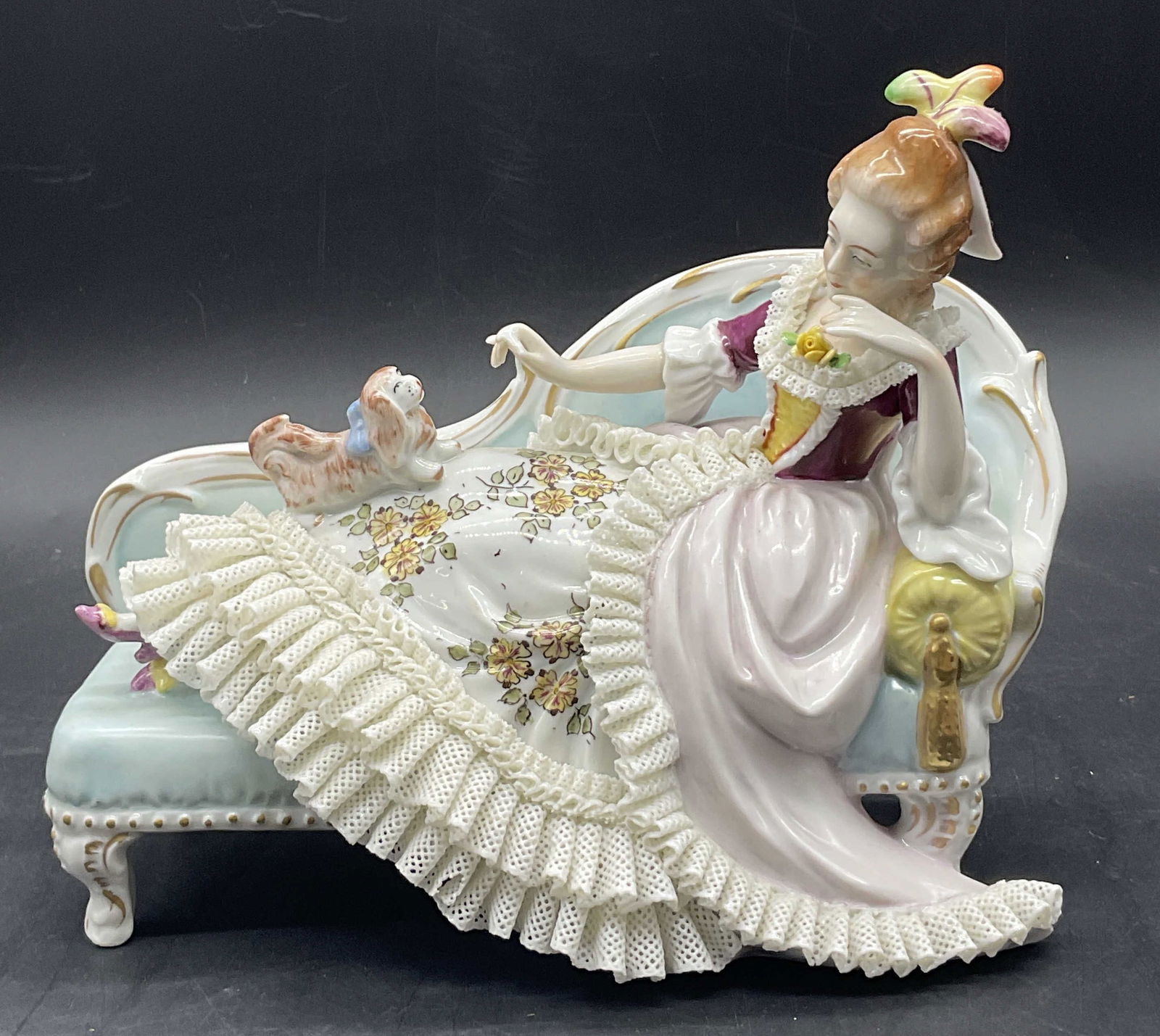 Sitzendorf Handmade Lace Porcelain Figural Germany: Sitzendorf Handmade Lace Porcelain Female Figural. The woman is depicted lounging on a chaise and feeding a dog. Underside reads Hand Made, Made in Germany. Trademark appears to be for Sitzendorf. Mea