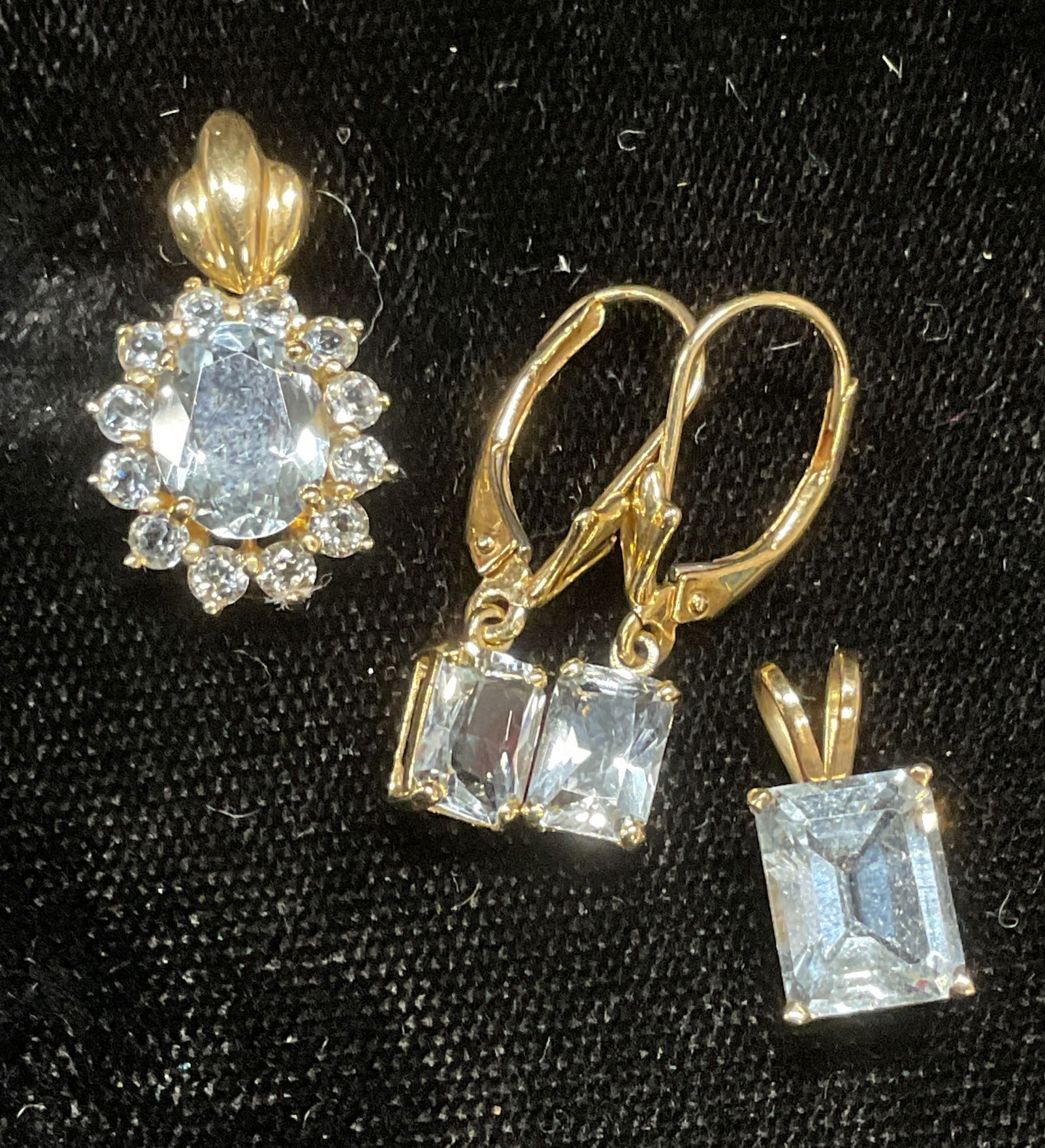 Lot 3 10k & 14k Y Gold Semiprecious Jewelry: Lot of 3 yellow gold and blue semiprecious stone jewelry pieces. Pendant with oval cut stone and halo, marked 14k, made in Mexico. Pendant with emerald cut stone, marked 10k. Earrings with emerald cut