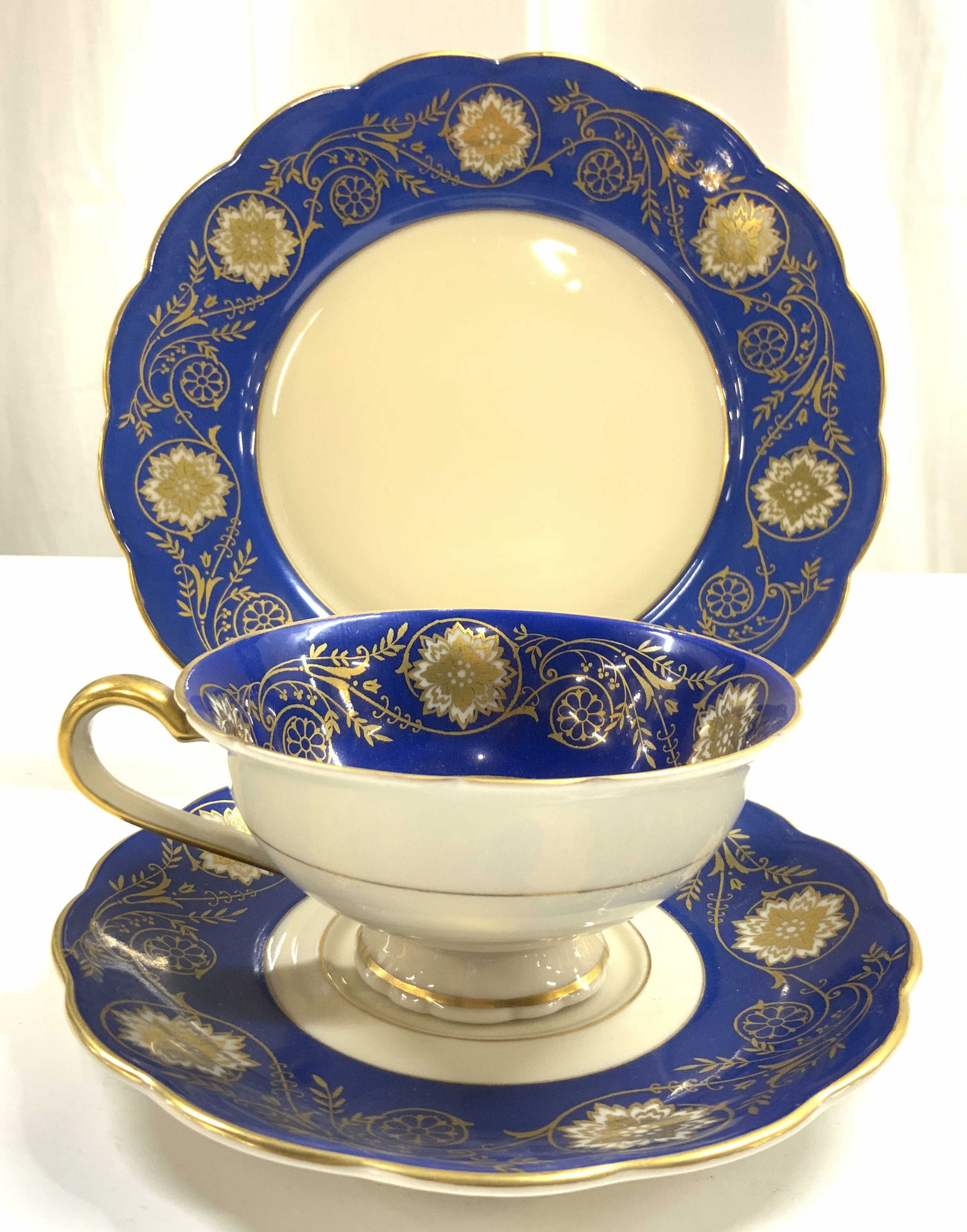 KONIGL PR TETTAU Set3 Porc Plate Teacup & Saucer: Undersides read KONIGL PR TETTAU GERMANY. Lot includes 1 plate, 1 saucer, & 1 teacups. Each piece has blue rims with gilt floral, leaf, and vine detail. Plate measures approximately 7.75 inches wide. 