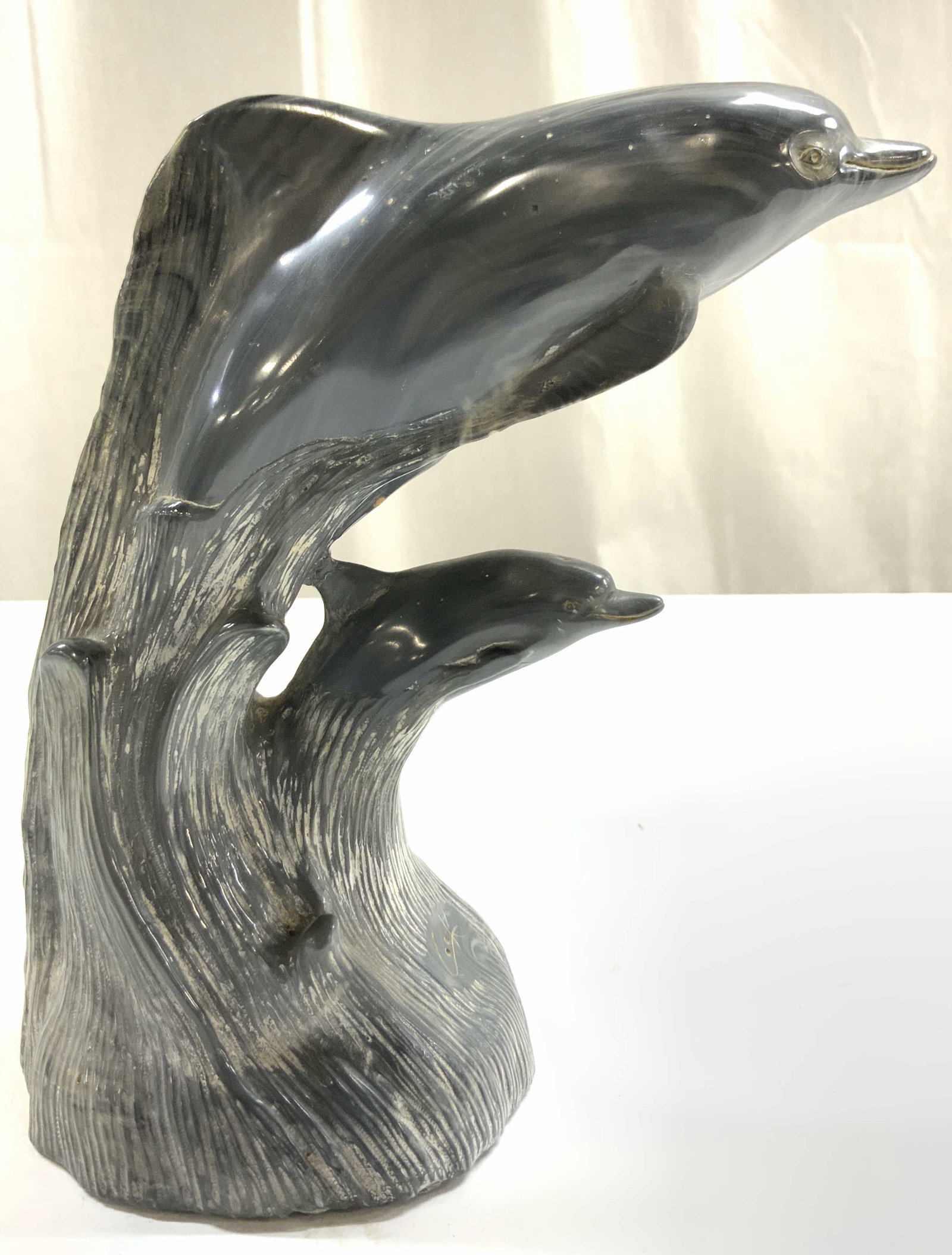 COOK COMPANY Cultured Grey Onyx Dolphin: Tag on Underside reads COOK COMPANY CULTURED GREY ONYX. Piece is grey toned, depicts 2 leaping dolphin figures. Piece is crafted from cultured onyx as stated on tag. Piece measures approximately 7 inc
