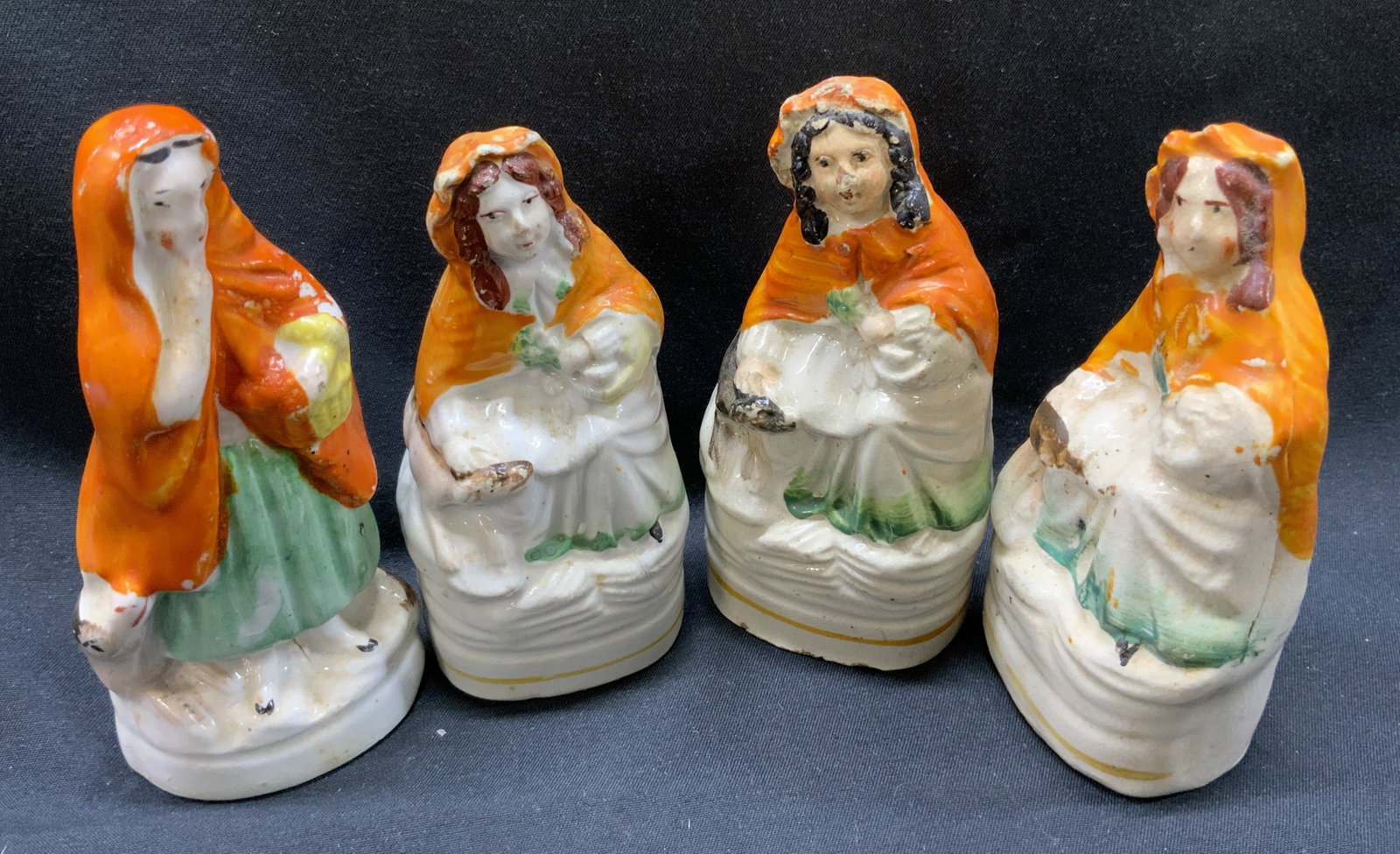 Lot 4 Antique Little Red Riding Hood Figurals: Lot 4 Antique Little Red Riding Hood Figurals 4 porcelain figural, they all have orange hooded capes with green dresses. They are each holding a white or yellow basket. Including a wolf near their fee