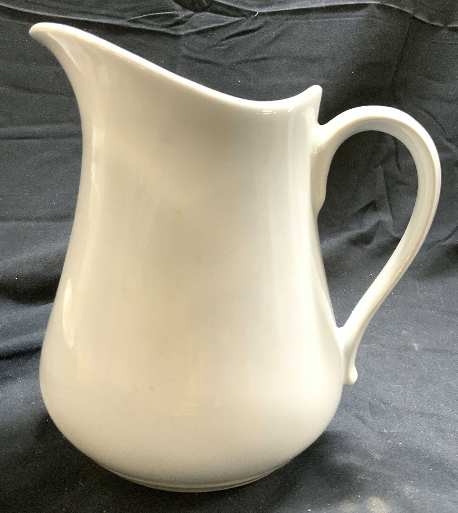 CHAUVIGNY FD Porcelain Pitcher White FRANCE: Underside reads CHAUVIGNY FD FRANCE. Pitcher is white toned and porcelain. Piece has half heart form handle. Pitcher measures approximately 6.75 inches tall 6.5 inches deep 5 inches wide. Pitcher, por