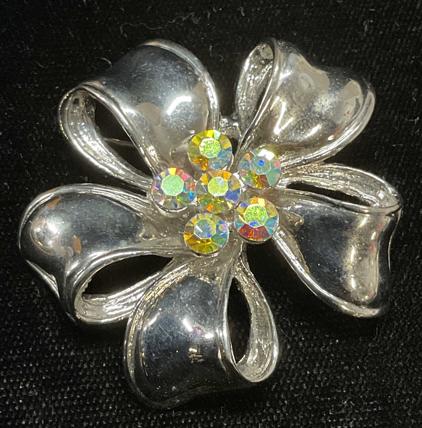 Vintage Silver Tone Crystal Flower Brooch: Vintage silver tone flower ribbon brooch with crystal. Measures approx 1.5 inches wide. Some wear including scratching observed. Jewelry, estate jewelry, costume jewelry, cocktail jewelry, fashion jew