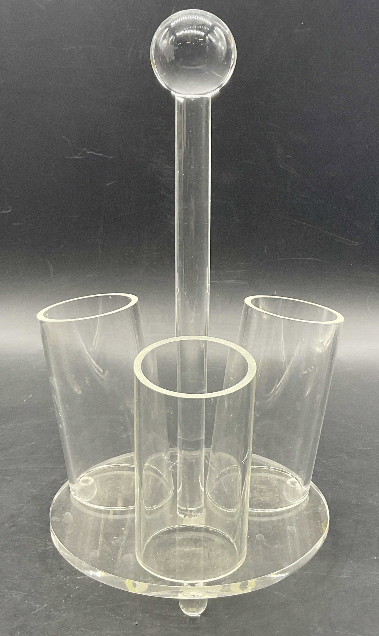 Acrylic Tabletop Footed Organizer: Acrylic Tabletop Footed Organizer. Three cylindrical storage compartments. Ball feet to the underside. Spherical accent to the top. Measures approx. 10.25H x 5.5W in. Chipping and surface wear present