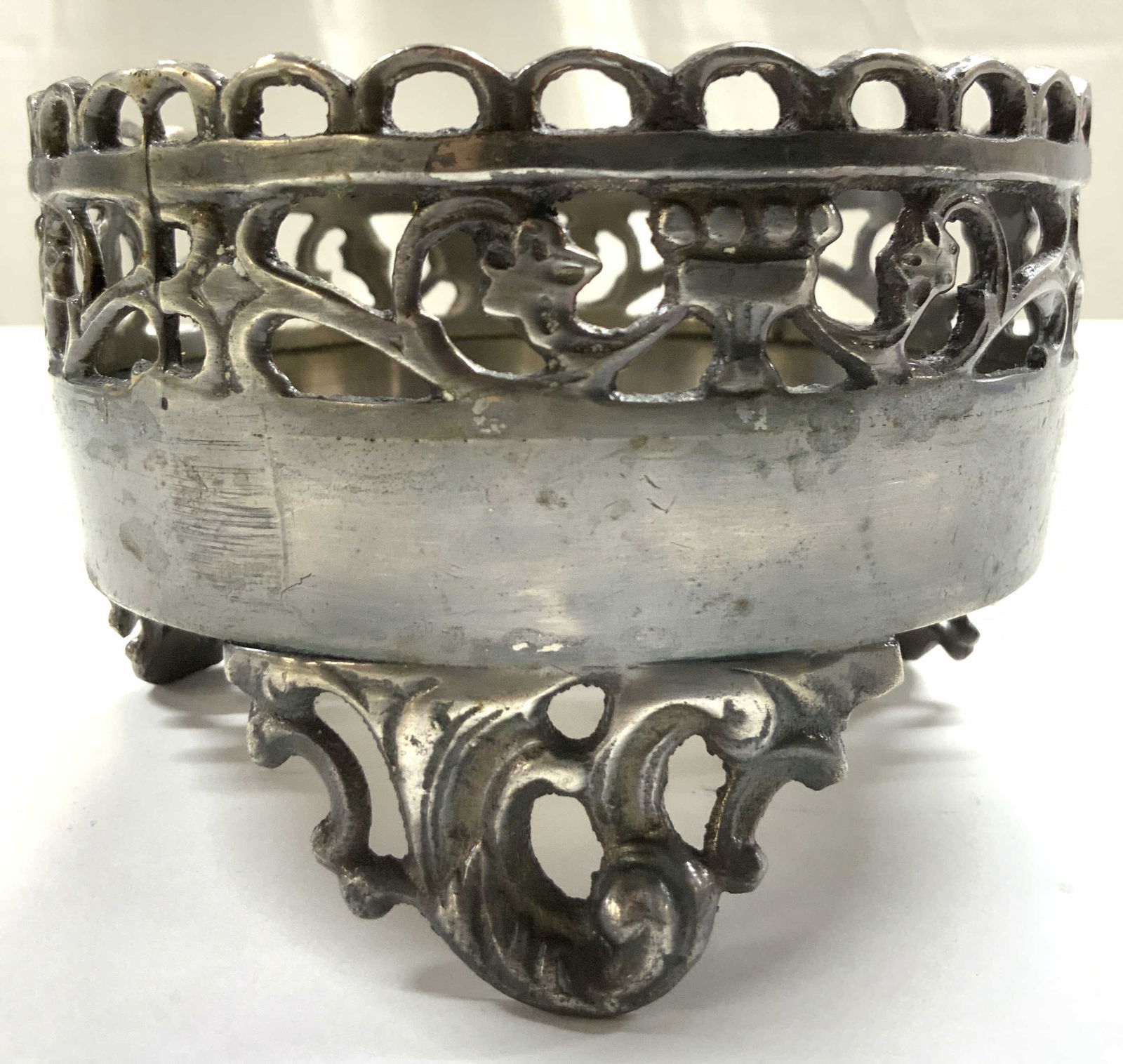 Vintage Footed Pewter Coaster W Feet: Coaster is vintage. Piece is silver toned and metal, appears to be pewter. Coaster has pierced gallery. Piece has 3 scrolled feet. Coaster measures approximately 4.75 inches wide 3 inches tall. Coaste