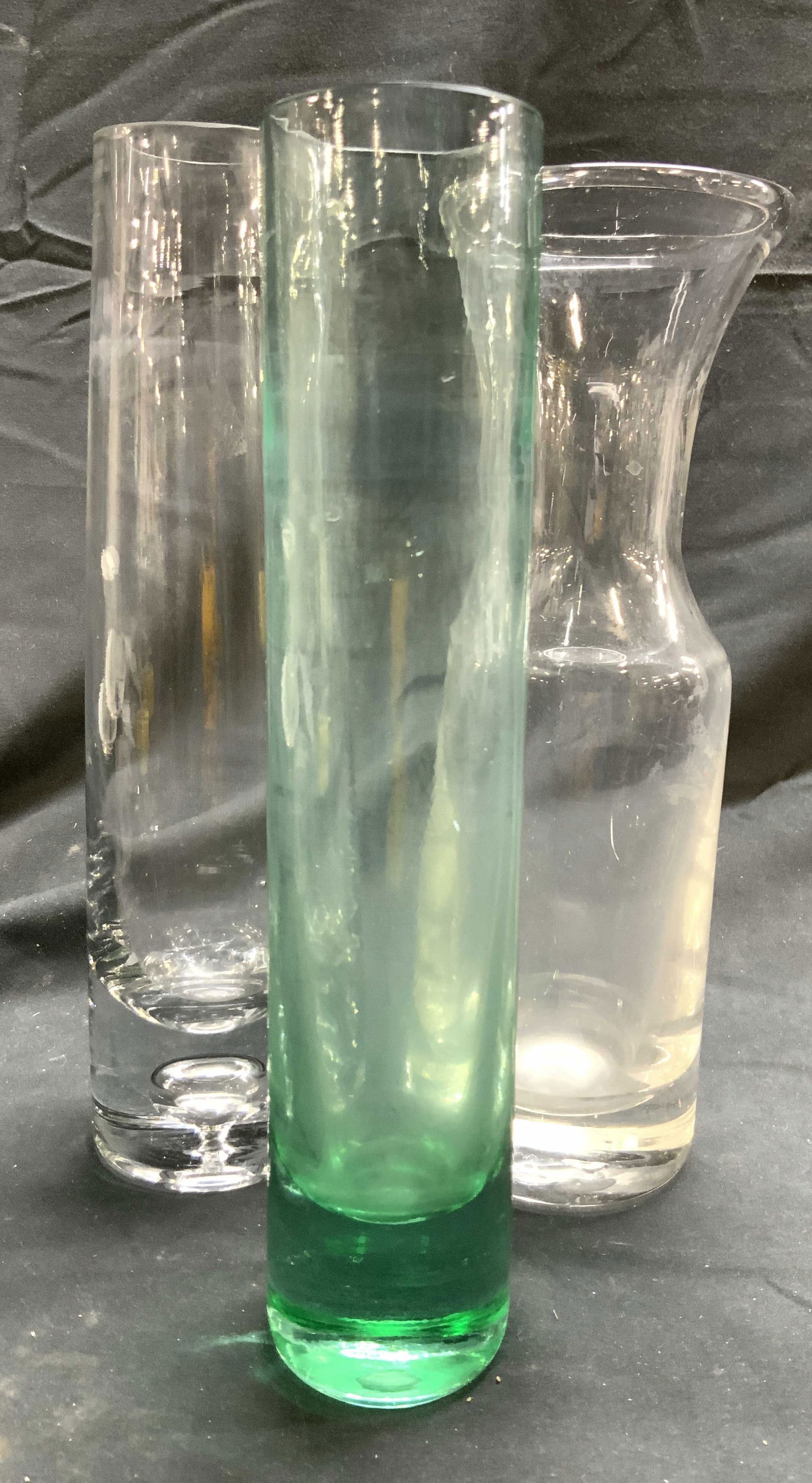 Lot 3 Art Glass Vases Vessels: Lot includes 3 vases. Each are glass. Includes 1 green, 1 with bubble base, & 1 that tapers inward at neck. Each have thick walled bases. Largest vessel measures approximately 9.5 inches tall 2.5 inch