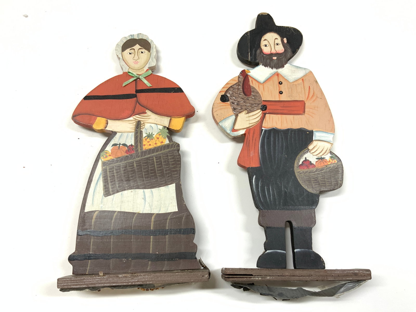 Lot 2 Vntg Wooden Pilgrim Amish Figures: Lot includes 2 pilgrim figures. Each are vintage and wooden. Figures appear to possibly be hand painted. Includes 1 male & 1 female figure. Each piece has rectangular form bases. Largest figure measur