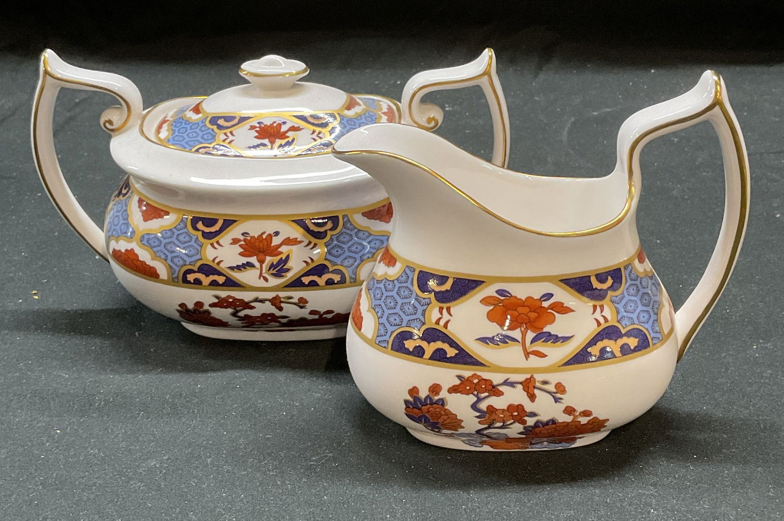 Pr Spode China Shima Creamer & Sugar Bowl England: Pair of Spode fine bone china creamer and lidded sugar bowl in Shima pattern. Signed on undersides. Made in England. Larger piece measures approx 6.25 x 3.75 x 3.75 inches. Both pieces have some wear