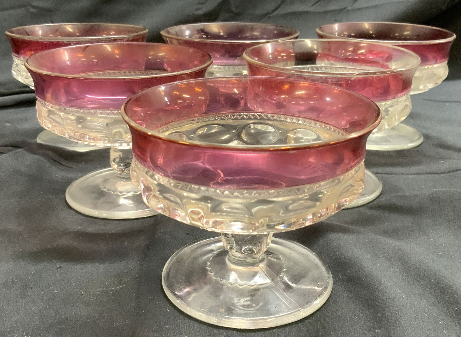 Set 6 Cranberry Gls Pedestaled Dessert Dishes: Lot includes 6 dessert dishes. Each are Pedestaled. Pieces each have cranberry toned rims. Glasses have circular form bases. Each piece measures approx 3 inches tall 3.75 inches wide. Art glass, cranb