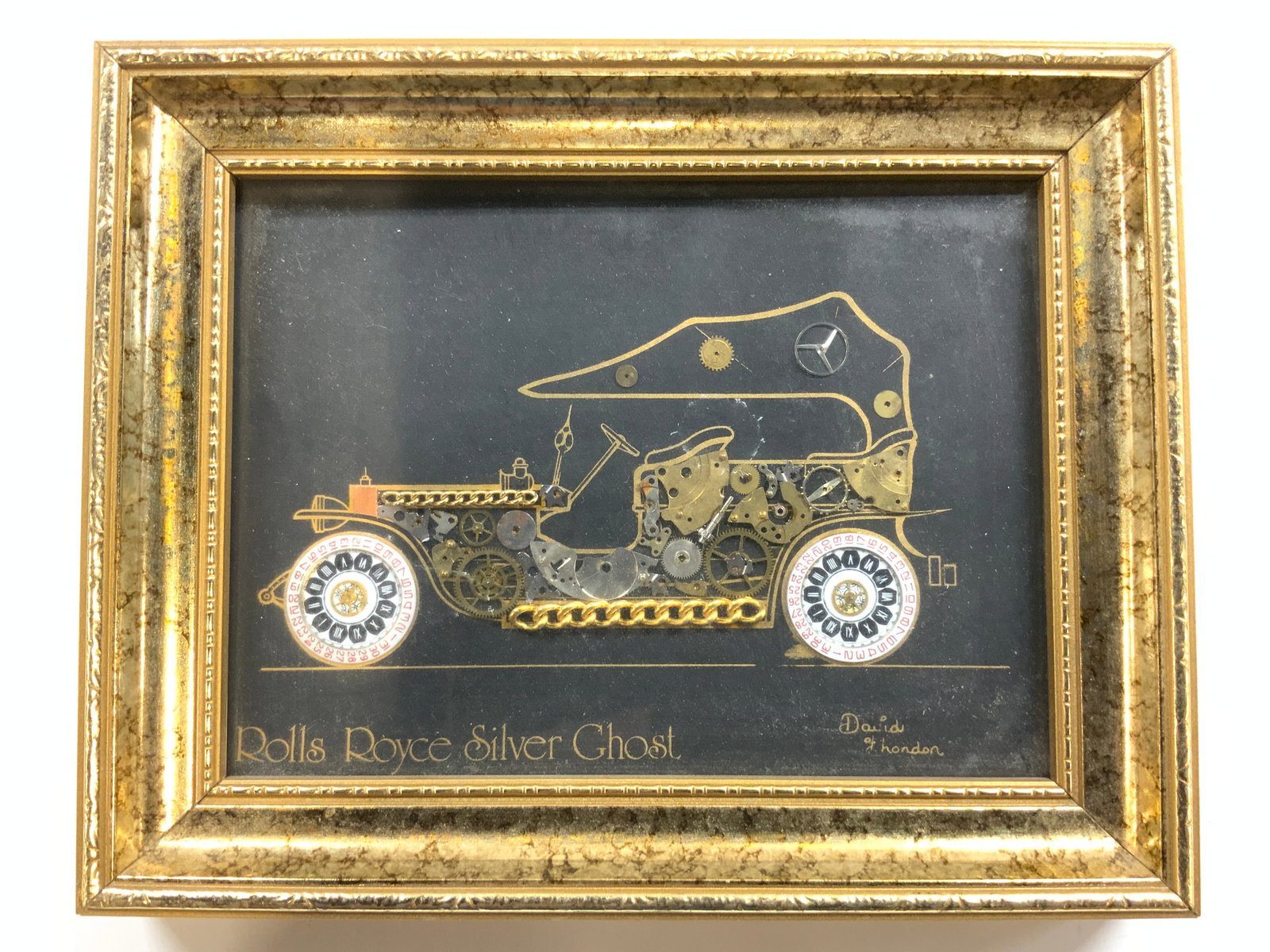 DAVID HONDEN Horological Montage R Royce Silv Ghst: Lower right corner signed DAVID HONDEN. Piece is within gilt wood frame. Horological collage depicts a Rolls Royce Silver Ghost. Frame measures approximately 7.5 inches wide 6 inches tall. horological