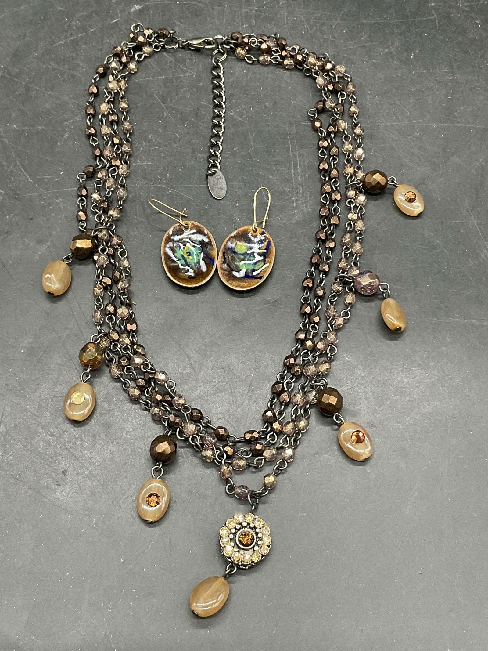 Lot 2 SEASONAL WHISPERS Necklace & Enamel Earrings: A lot consisting of a pair of earrings and a necklace. The earrings are oval shaped, crafted from metal, and decorated with enamelwork. The backings are for pierced ears. Earrings are 1 1/2 in total l