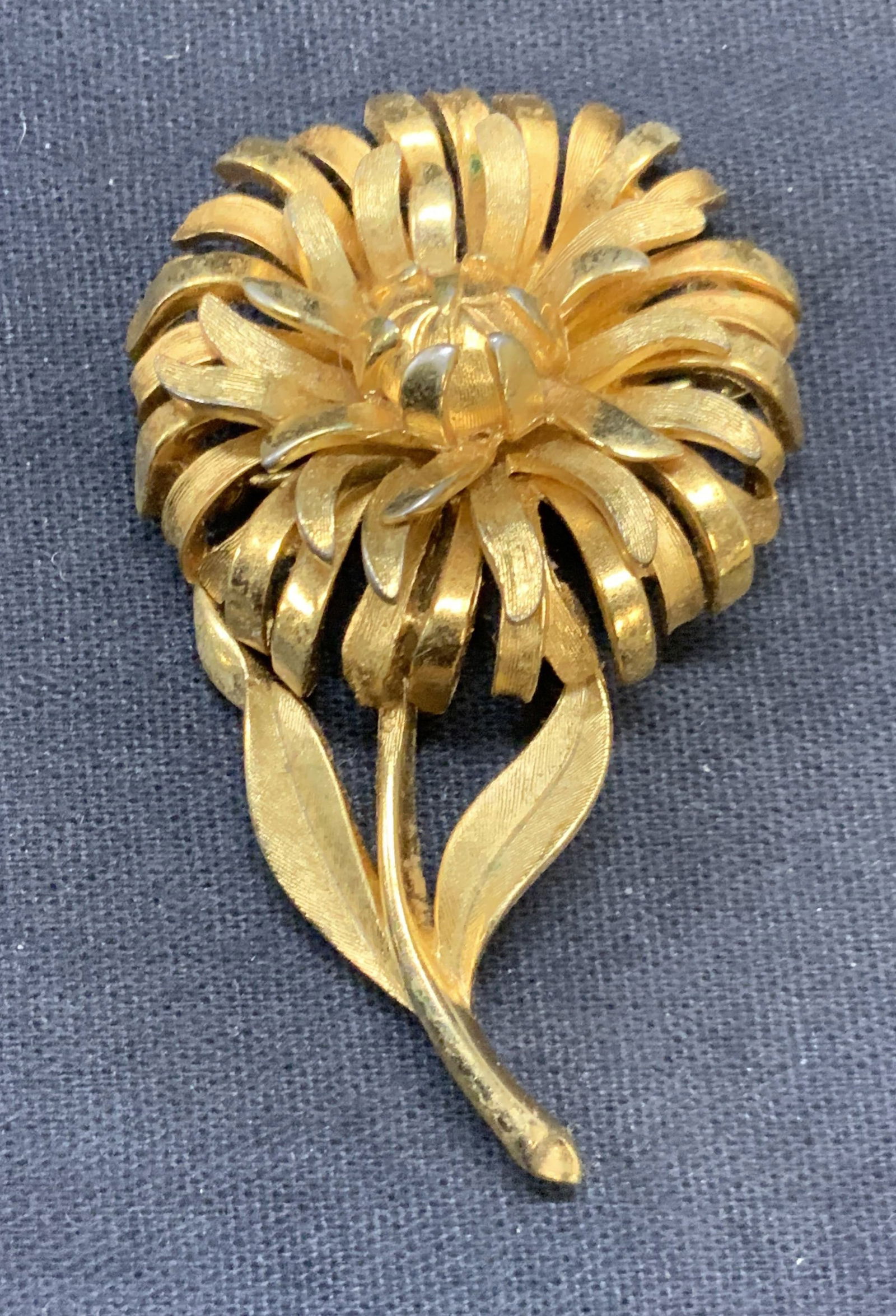 Vintage TRIFARI Gold Tone Flower Brooch: Vintage TRIFARI gold tone flower motif brooch. Signed to underside. Hinge pin to underside. Measures approx. 2.25 x 1.25 inches. Some surface wear including scratching observed. Estate jewelry, costum