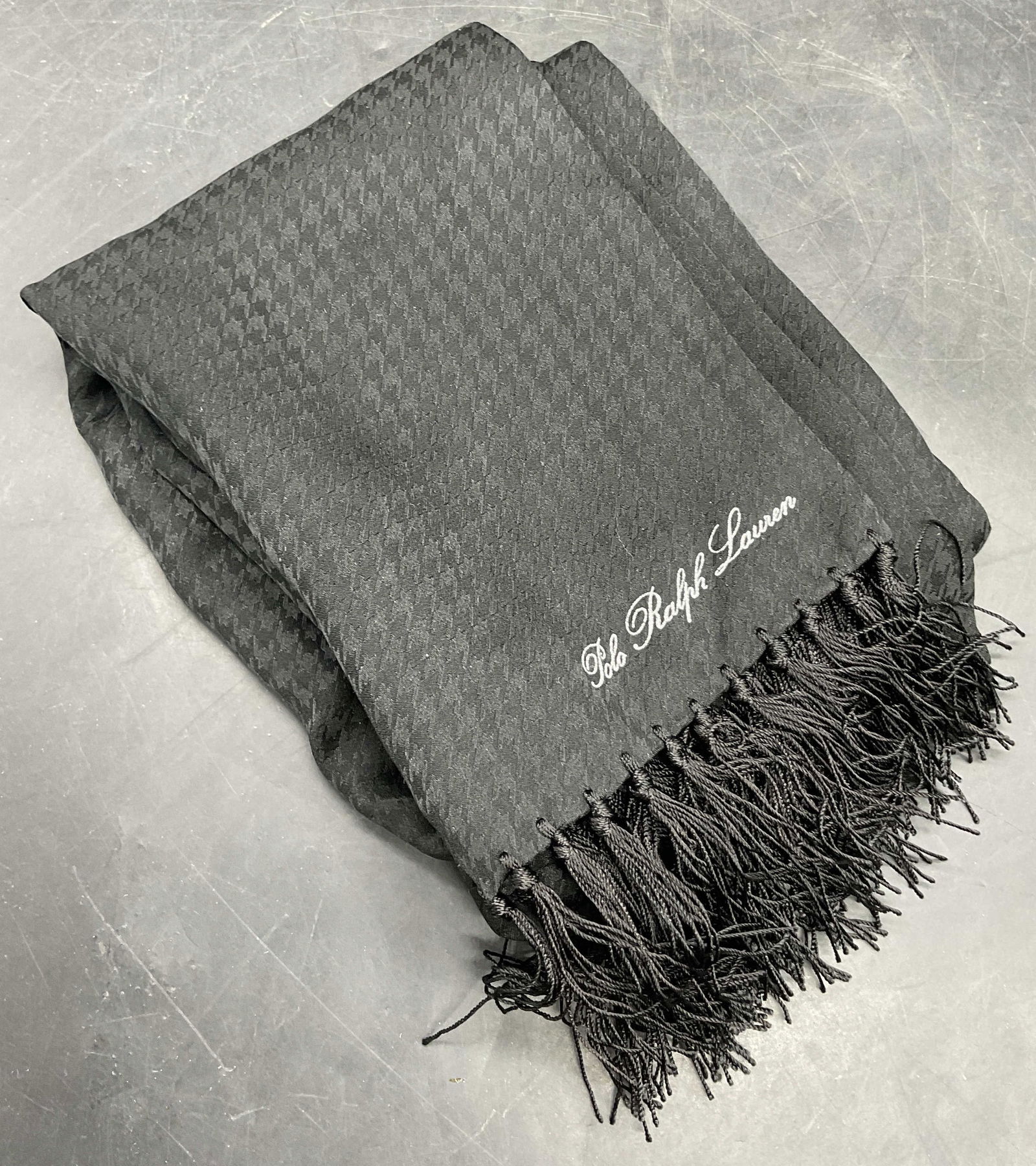 POLO RALPH LAUREN Black 100% Silk Scarf: POLO RALPH LAUREN Black 100% Silk Scarf. Fringe trim edges. Tag reads POLO RALPH LAUREN 100% Silk. Measures approx. 60W x 10L in. Surface wear consistent with age, use, and exposure. Wearables, fashio