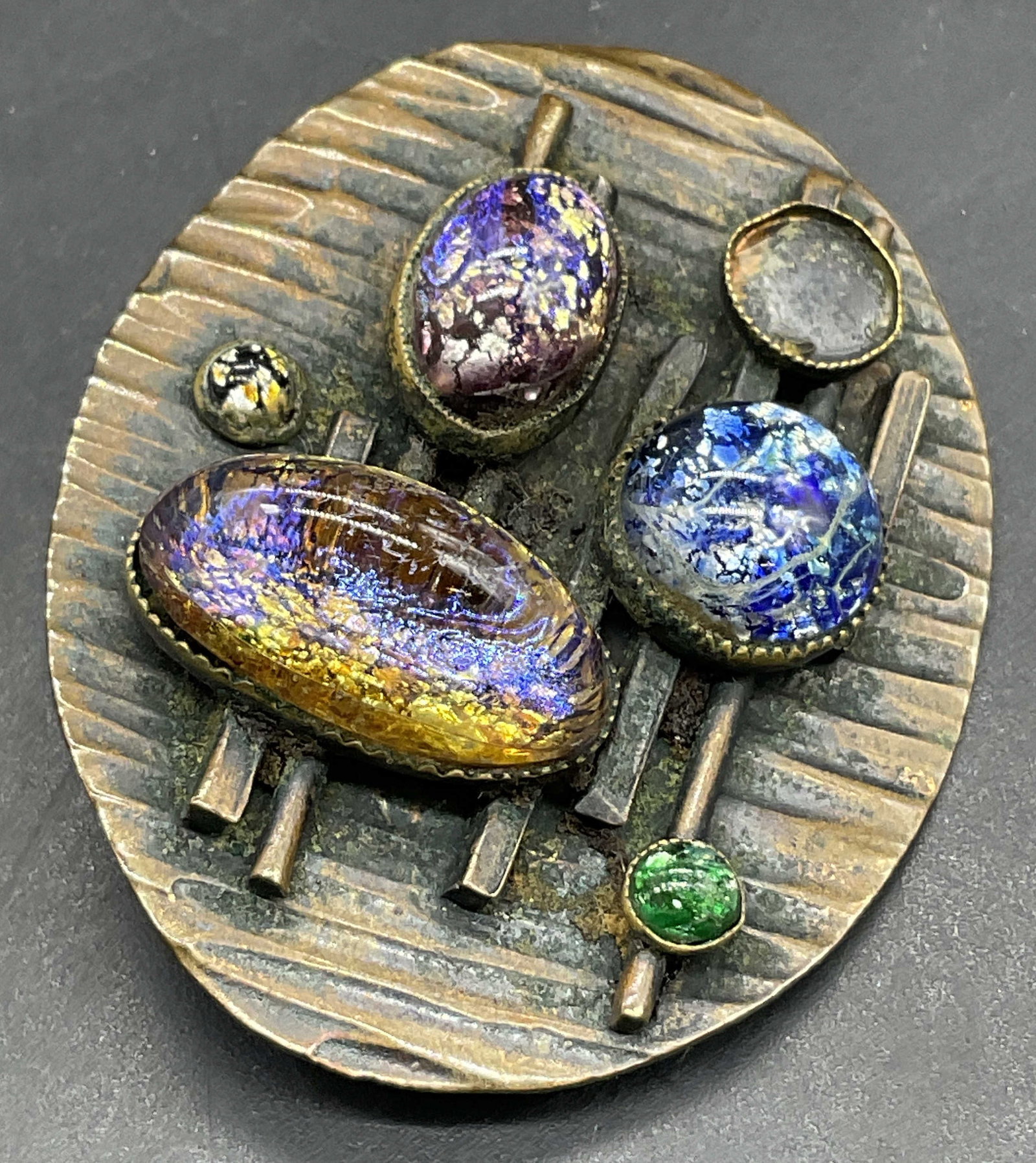 Vintage Foil Cabochon Abstract Design Metal Brooch: Vintage Foil Cabochon Abstract Design Metal Brooch. Multicolored foil cabochons to the obverse. Underside features a metal pin closure. Measures approx. 1.75L x 1.5W in. Losses, surface wear, and disc