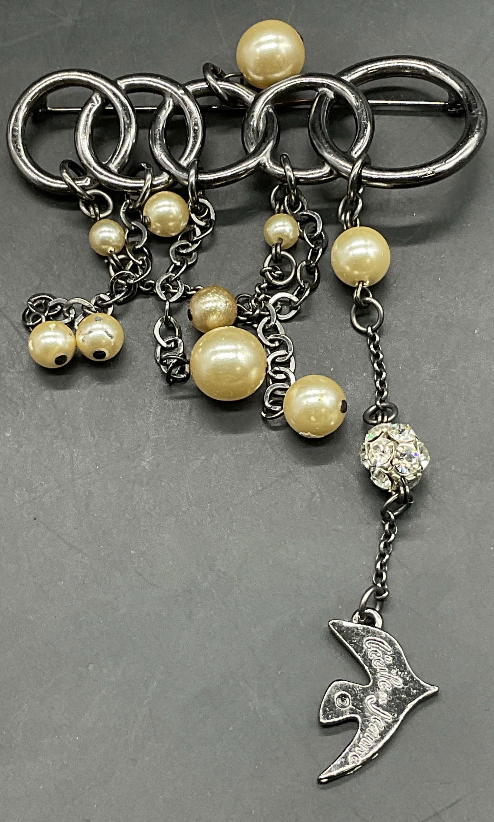 CECILE JEANNE COUTURE Beaded Dangle Chain Brooch: CECILE & JEANNE COUTURE Beaded Dangle Chain Brooch. Crafted from silver tone metal and decorated with pearlescent & crystal beads. Bird charm is marked CECILE & JEANNE COUTURE. Metal pin closure to re