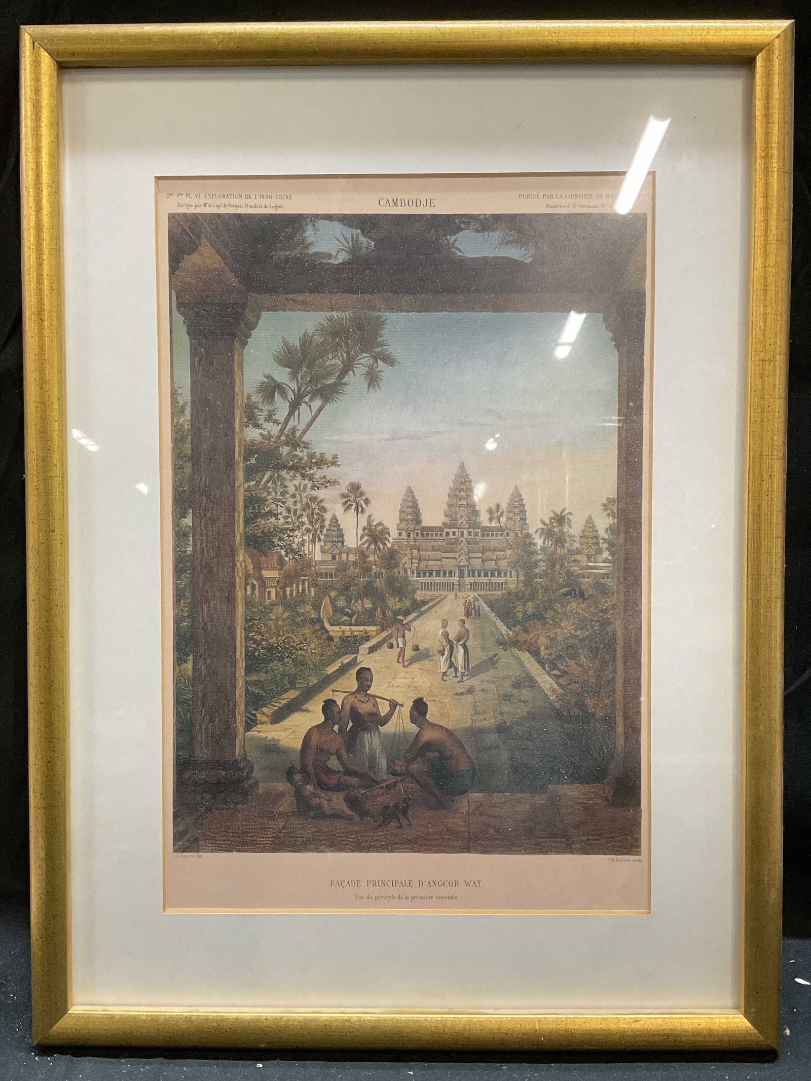Framed Angkor Wat Cambodian Scene Print: Framed and matted print in color. Appears to be engraving. Date unknown. From exploration De L Indo Chine. Angkor Wat. Cambodian landscape scene with view of Angkor Wat and figures. Gilt wood frame. C