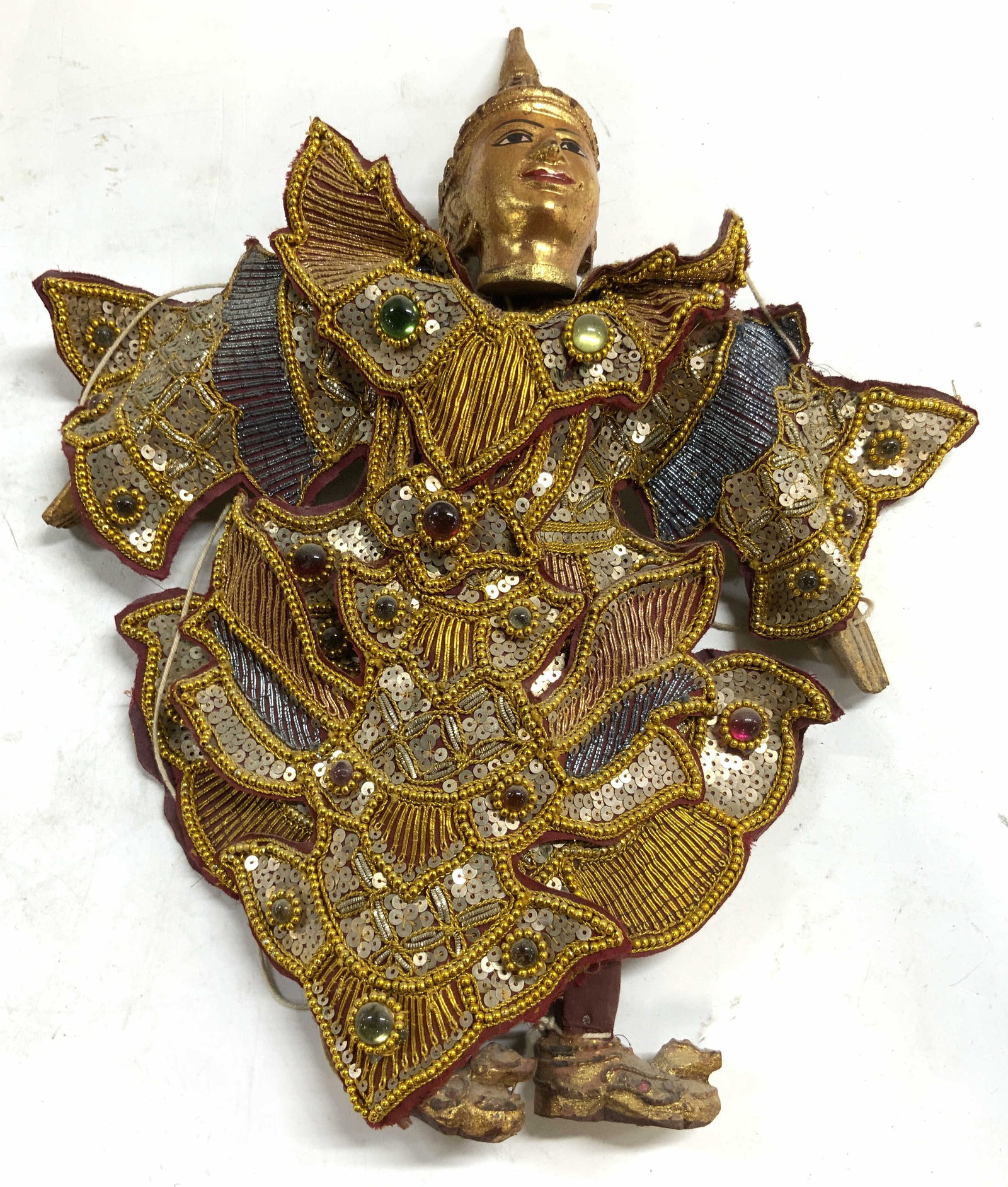 Vintage Wood & Sequin Asian Marionette Puppet: Marionette is vintage. Asian marionette puppet, wood, fabric and sequin. Piece has intricately detailed attire. Puppet has gilt wood head with painted facial features. Puppet measures approximately 16