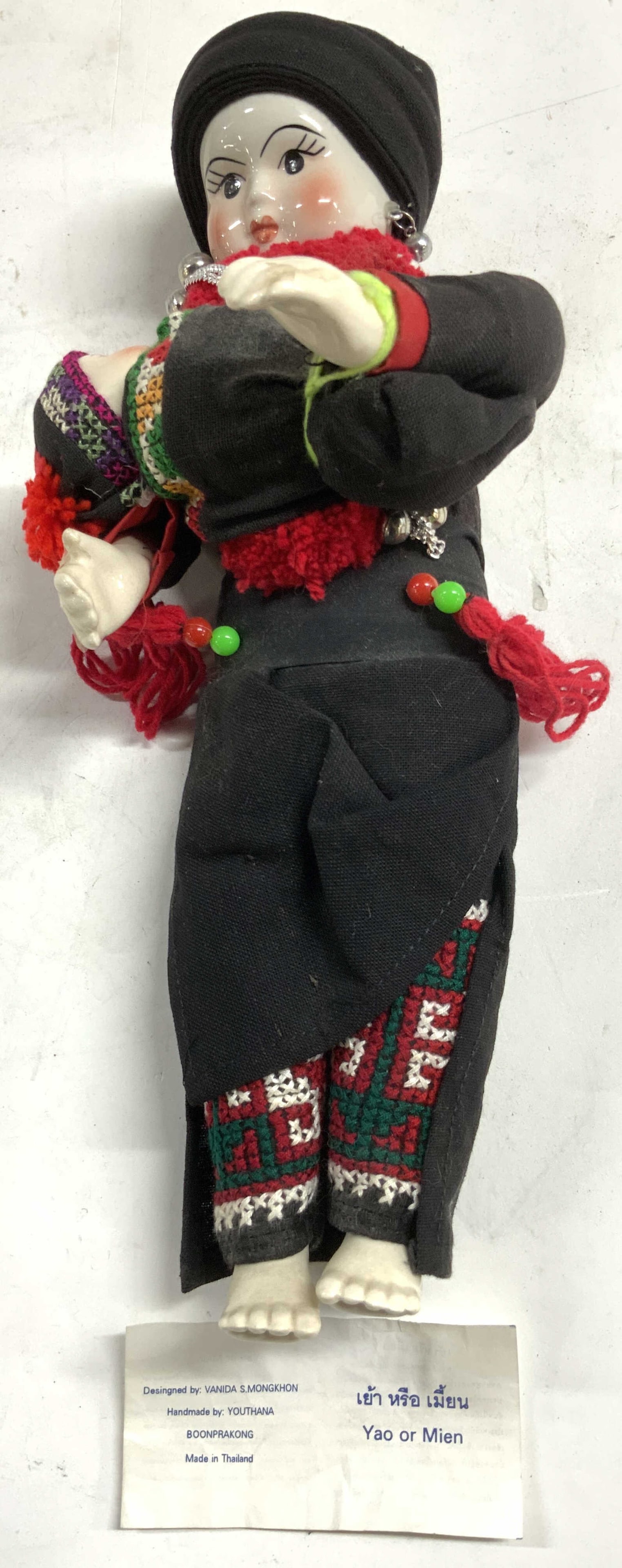 YOUTHANA Yao or Mien Thai Folk Art Doll: Tag reads YAO OR MEIN HANDMADE BY YOUTHANA DESIGNED BY VANIDA S. MONGKHON. Doll depicts a female figure and child. Piece is porcelain and fabric. Piece appears to have hand painted elements. Doll is v