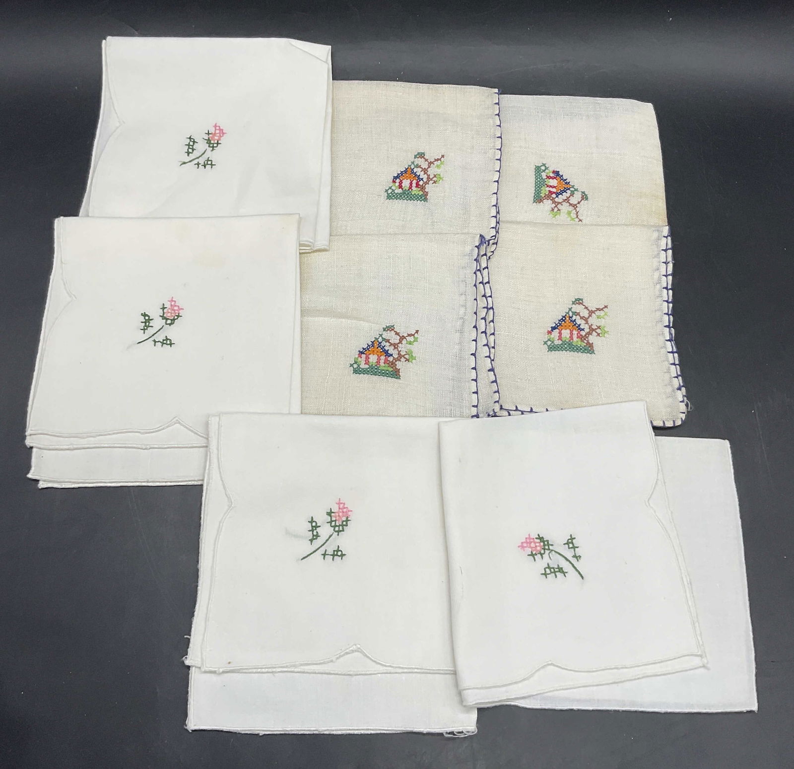 Lot 8 Vintage Embroidered Fabric Napkins: Lot of 8 Vintage Embroidered Fabric Napkins. Napkins feature a pink and green floral motif or a house in a nature setting motif. The pink and green embroider white fabric napkins measure approx. 10.5L