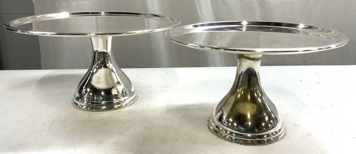 POTTERY BARN Lot 2 Chrome Cake Stands: Undersides are trademarked POTTERY BARN. Lot includes 2 cake stands. Each are silver toned, appear to be chrome possibly white metal. Cake stands are each pedestaled. Top surfaces have circular forms.