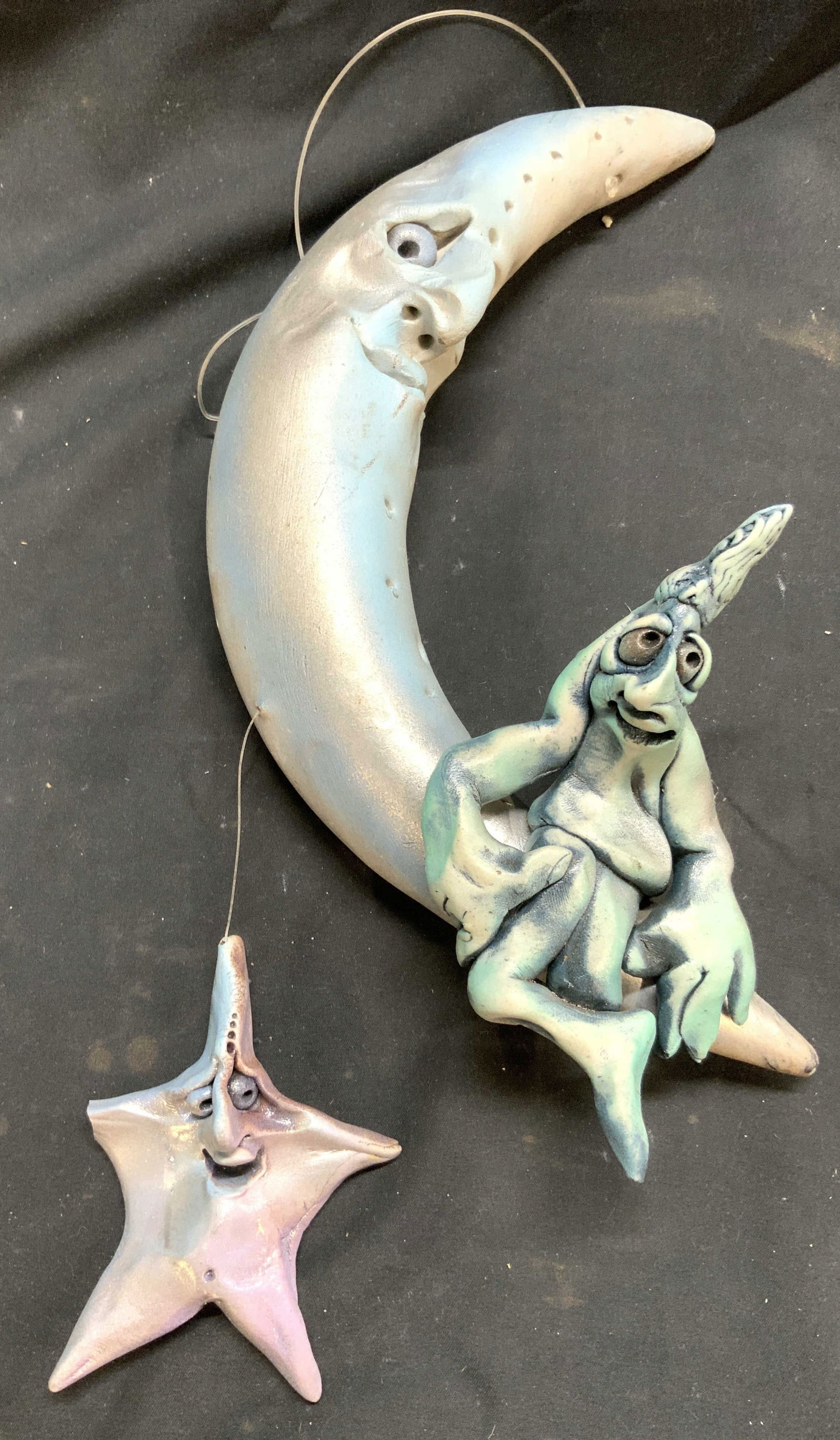STEVEN LEE SMELTZER Clay Moon & Stars Sculpture: Sculpture appears to be by STEVEN LEE SMELTZER (no apparent markings). Piece is hand crafted from clay. Depicts a crescent moon with a star seated at base & additional star hanging from moon. Each has