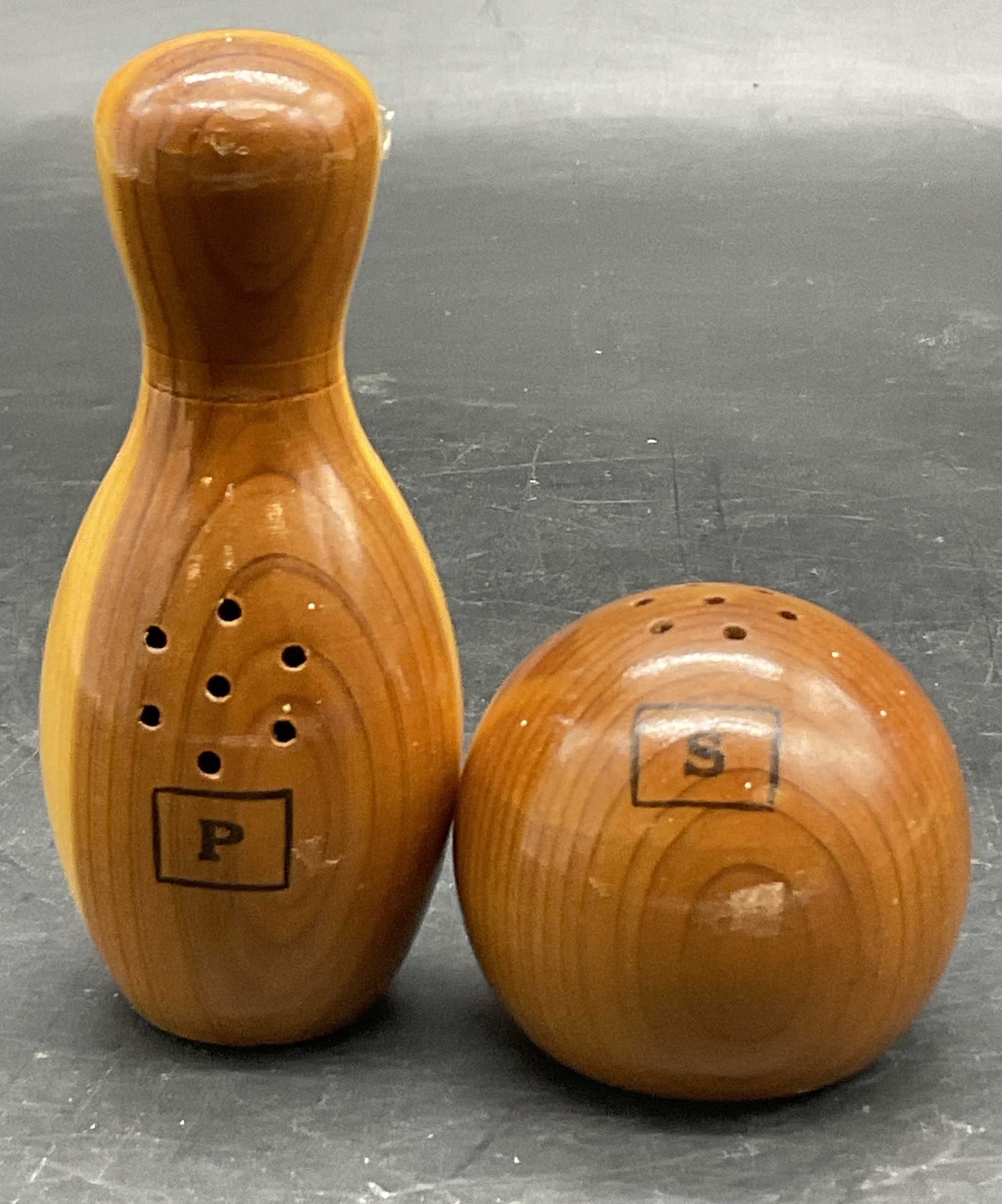 Pair Vintage Bowling Motif Salt & Pepper Shakers: Pair of Vintage Bowling Motif Salt & Pepper Shakers. One bowling pin and one bowling ball. Crafted from wood. Metal stoppers to the underside. Bowling pin measures approx. 3.5H x 1.25W in. Surface wea