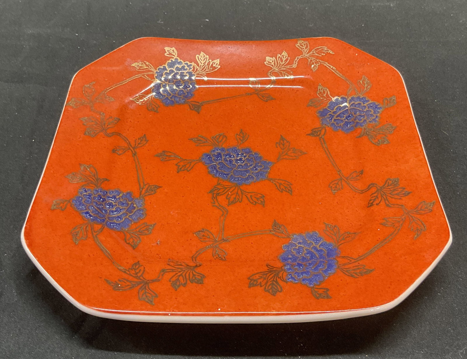Sgn Asian Red & Blue Floral Porcelain Plate: Asian porcelain plate. Hand painted in red and blue with gilt decoration and floral motif. Signed on underside. Measures approx 7.5 x 7.5 inches. Some wear including scratching observed. Asian plate, 