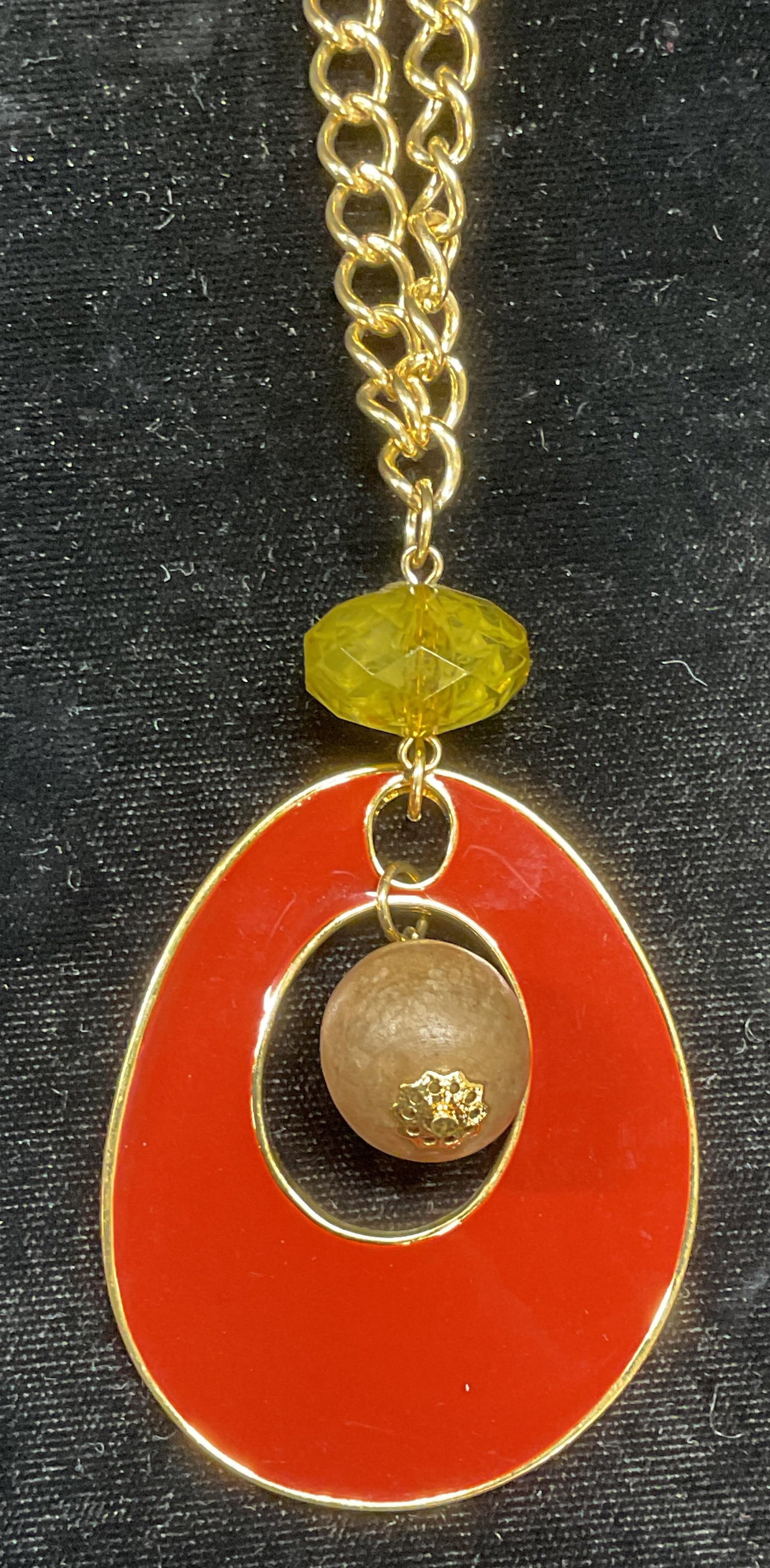 Gold Tn Enamel, Wood & Crystal Pendant Necklace: Gold tone pendant necklace. Red enamel, wood bead, and green crystal pendant. Drop length approx 15 inches. Pendant approx 3 inches long. Some wear including scratching observed. Jewelry, estate jewel