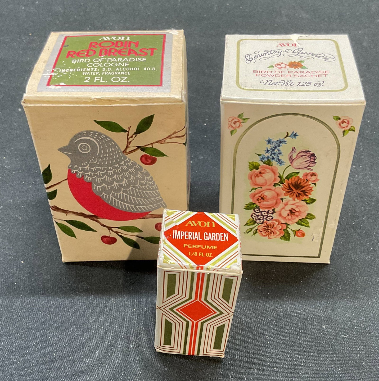 3 Avon Imperial Garden Bird Paradise Fragrances Bx: Lot of 3 vintage Avon fragrance products. Includes Imperial Garden perfume, Birds of Paradise Powder Sachet, and Birds of Paradise Cologne. All pieces as is, contents unknown. Largest box measures app