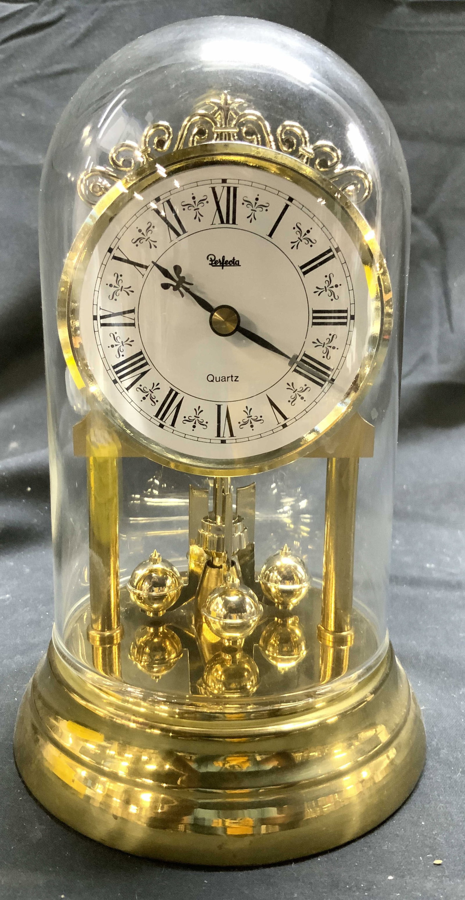 PERFECTA Vtg Gilt Metal Anniversary Clock: Clock face reads PERFECTA. Clock is gilt metal with white toned clock face with black Roman numerals and hands. Clock also has glass dome. Piece measures approximately 6.25 inches tall 4 inches wide. 