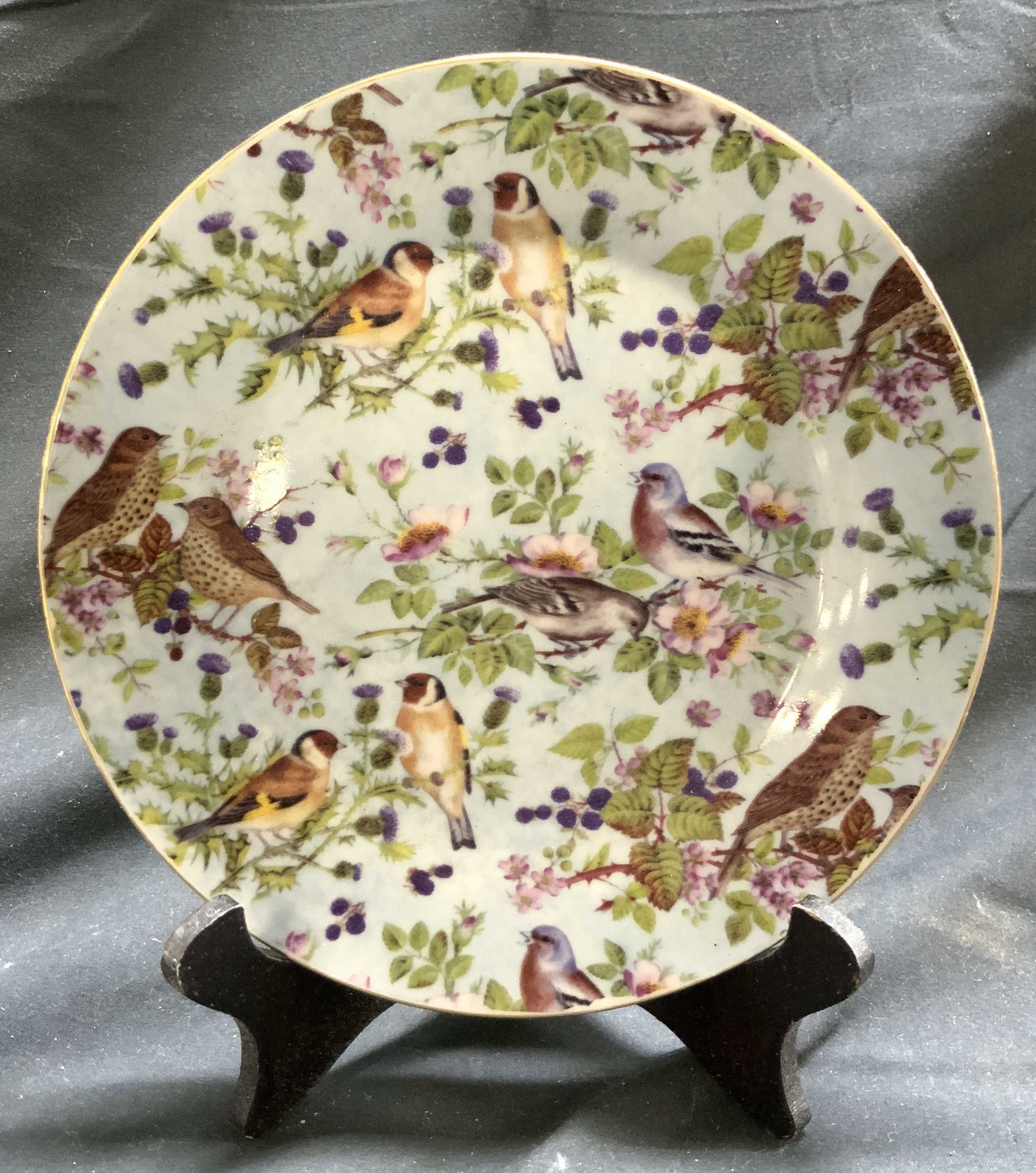 Mayfair Coll By Jay Floral & Bird Detail Porc Plte: Underside is marked MAYFAIR COLLECTION BY JAY. Plate is porcelain. Piece is light blue with multi toned floral, leaf and bird detail. Plate has gilt rim. Piece measures approximately 7.5 inches diamet