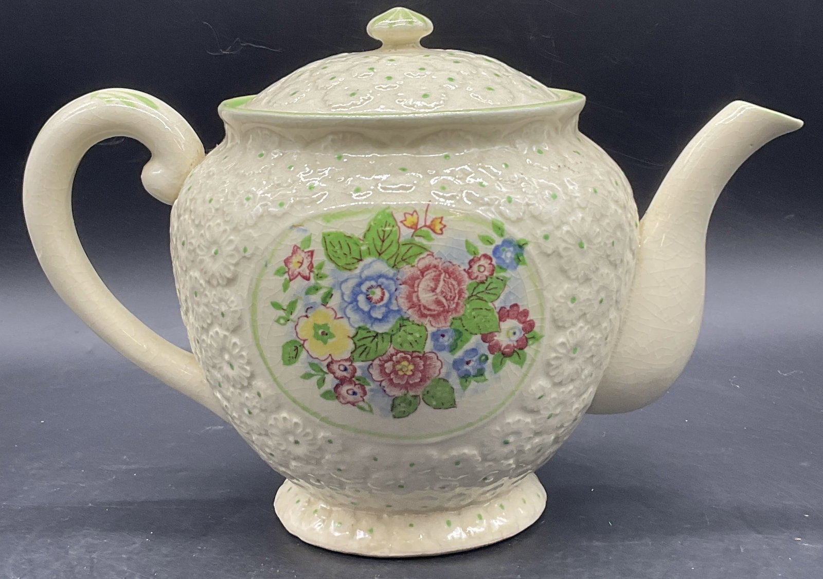 Vintage Hand Painted Floral Porcelain Teapot Japan: Vintage Hand Painted Floral Porcelain Teapot. Lidded. Raised floral porcelain accents to the piece alongside hand painted flowers and details. Underside reads Made in Japan. Measures approx. 6.75H x 1