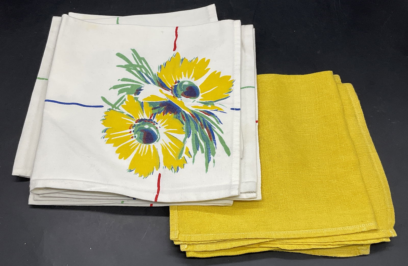 Lot 8 Vintage Fabric Napkins, Floral & Yellow: Lot of 8 Vintage Fabric Napkins. Pieces feature florals or solid yellow. The yellow napkins measure approx. 13.5L x 13.5W in. Crafted from sift hand fabric. Discoloration, surface wear, and loose thre