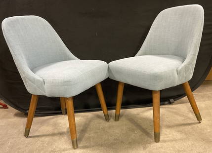 Pair Mid Century Modern Style Upholstered Chairs: Pair Mid Century Modern Style Upholstered Chairs. Blue hued upholstery with tapered wooden legs. Brass hued metal caps to the legs. Quilted backs. Measures approx. 32H x 18.5W x 18D in. Surface wear a