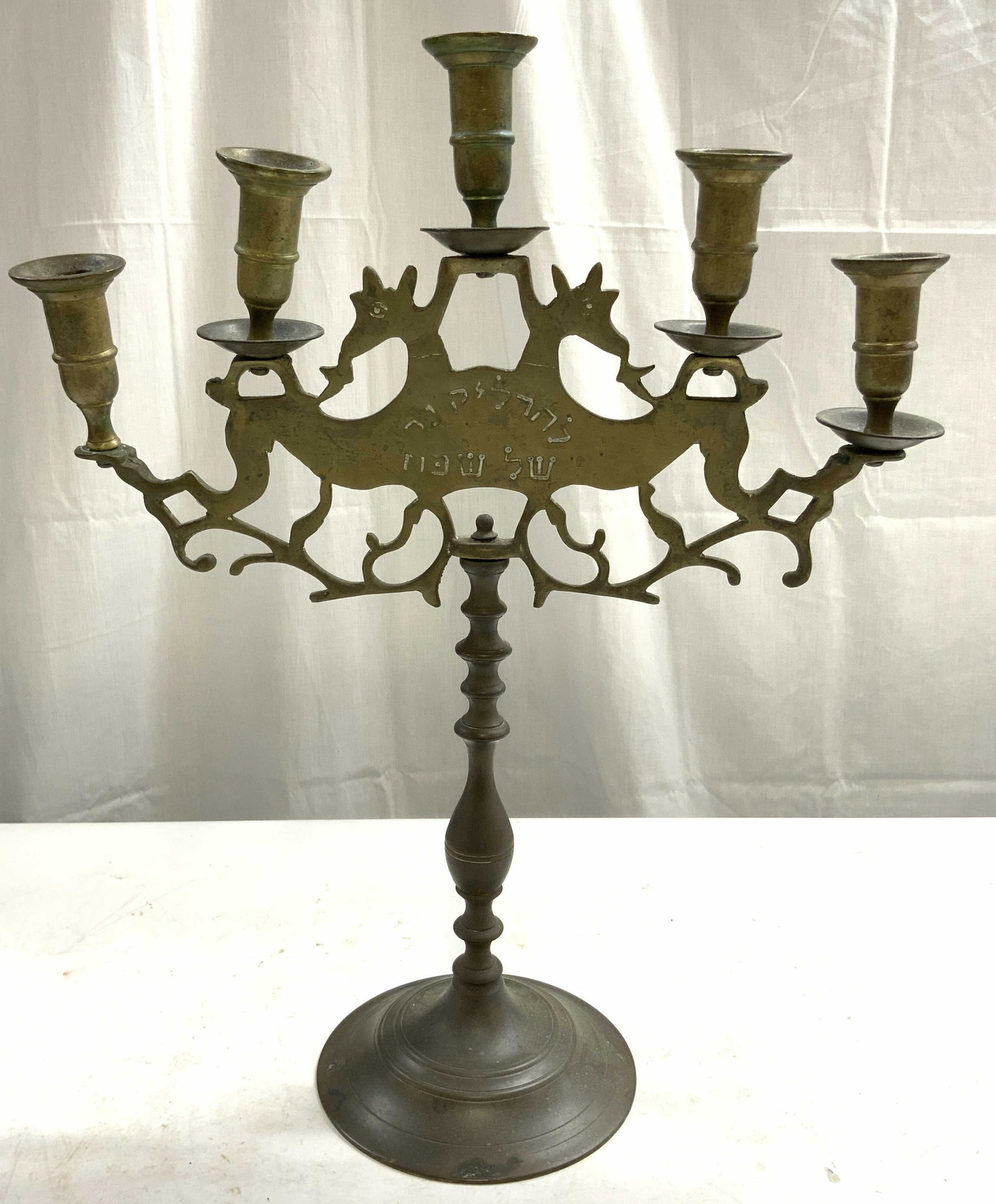 Antique Shabbat Judaica Brass Candelabra: Candelabra appears to be antique possibly vintage. Piece is brass. Candelabra has Hebrew characters. Piece has 5 arms. Base has circular form. Candelabra measures 17.5 inches tall 14 inches wide 5.5 i