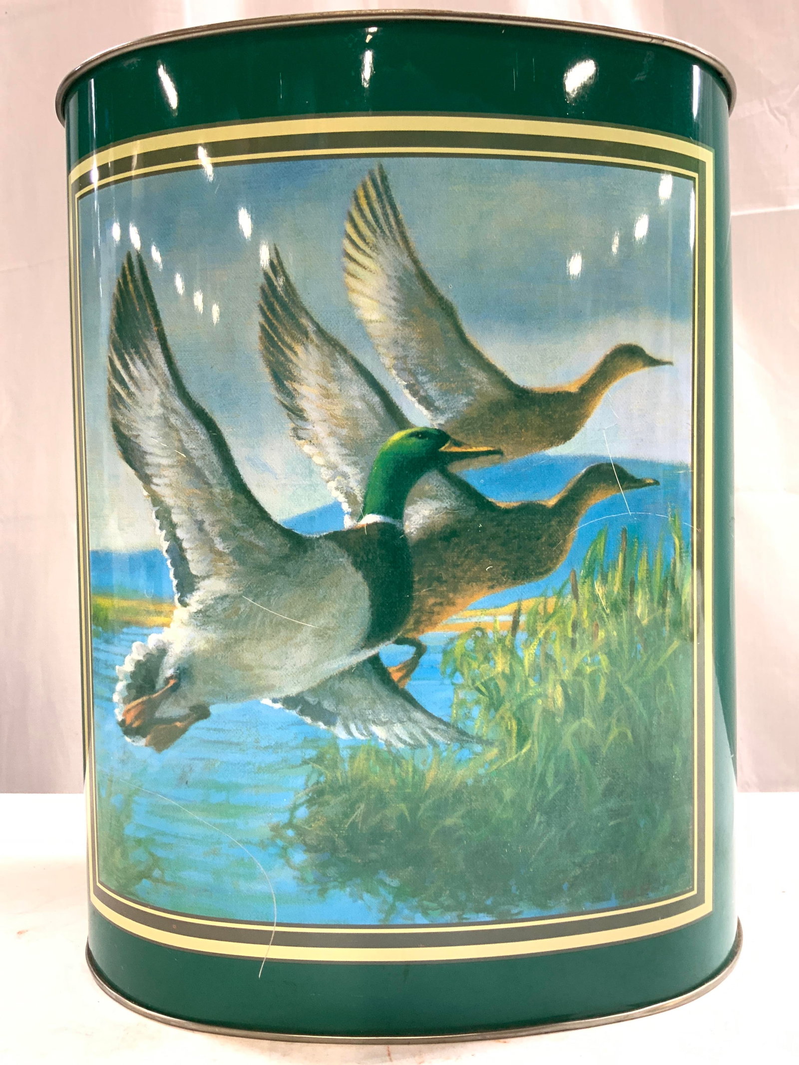 CHEINCO Toleware Duck Detailed Vessel USA: Underside reads CHEINCO MADE IN USA. Vessel is toleware. Piece has depiction of flying ducks on each side. Bin has green base tone. Interior is silver toned. Vessel has oval form. Piece measures appro
