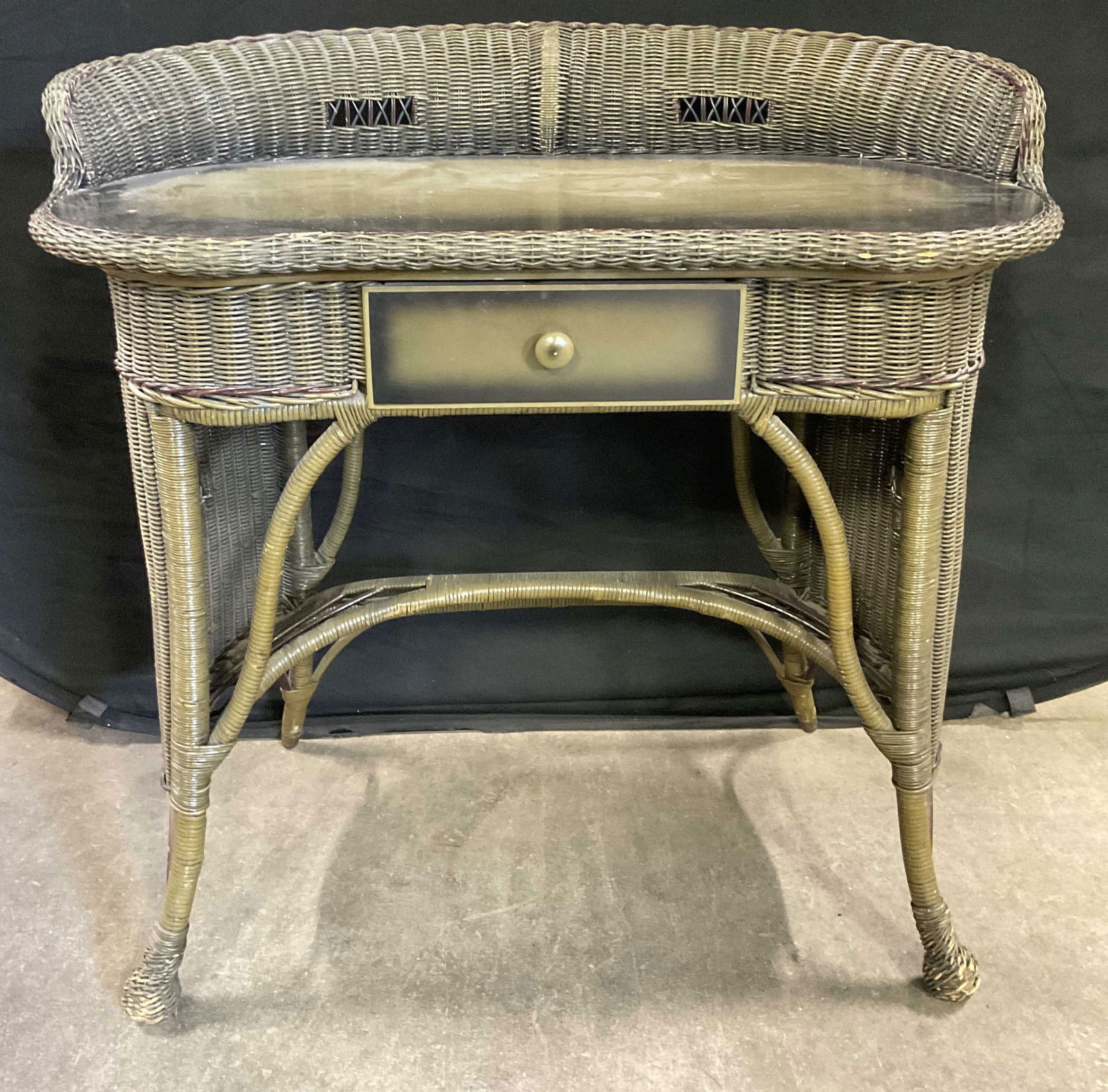 Vintage Woven Wicker One Drawer Desk: Vintage Woven Wicker One Drawer Desk. Painted primarily in green hues. One drawer to the obverse. Measures approx. 35W x 33.5H x 18D in. Losses to paint and wicker, discoloration, chipping, and surfac