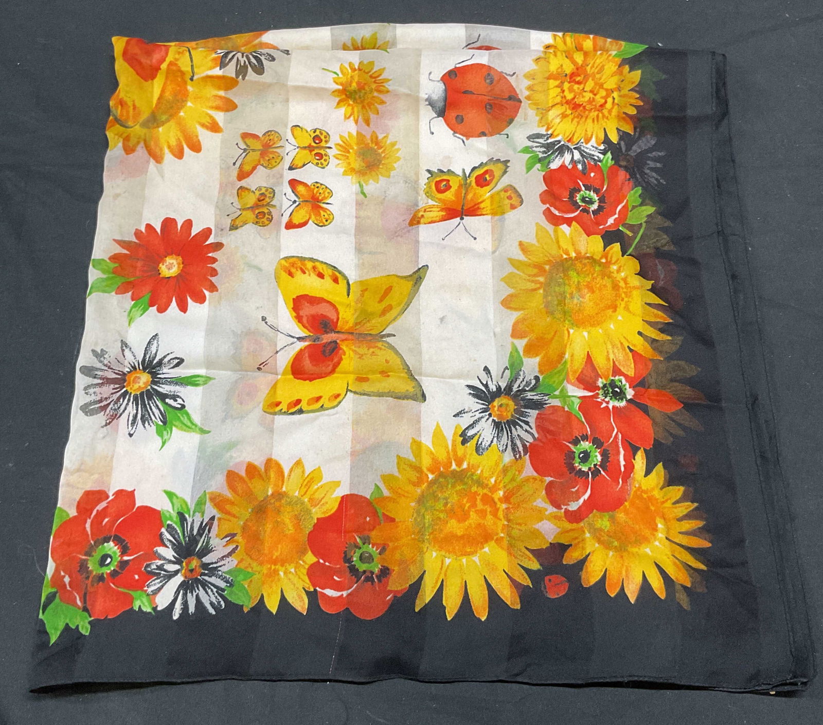 Vtg Sunflower, Butterfly, Ladybug Silk Scarf: Vintage scarf with sunflower, ladybug, and butterfly print in black, white, and orange. Feels like silk. Measures approx 33 x 33 inches. Some wear to material consistent with exposure. Scarf, vintage