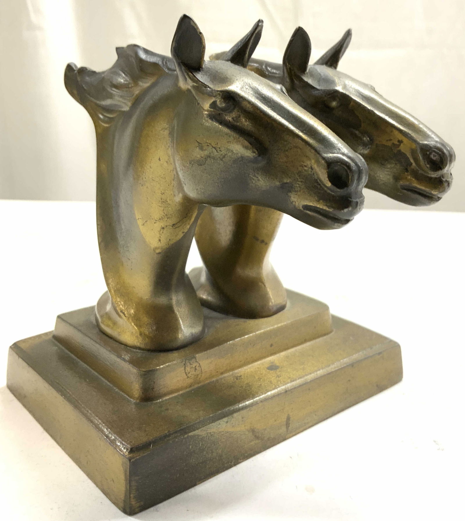 FRANKART Art Deco Horse Head Cast Metal Bookend: Underside reads FRANKART INC. Art Deco. Piece is cast metal with bronzed finish. Art deco bookends with double horse head form. Base has rectangular form. Bookend measures approximately 5 inches wide