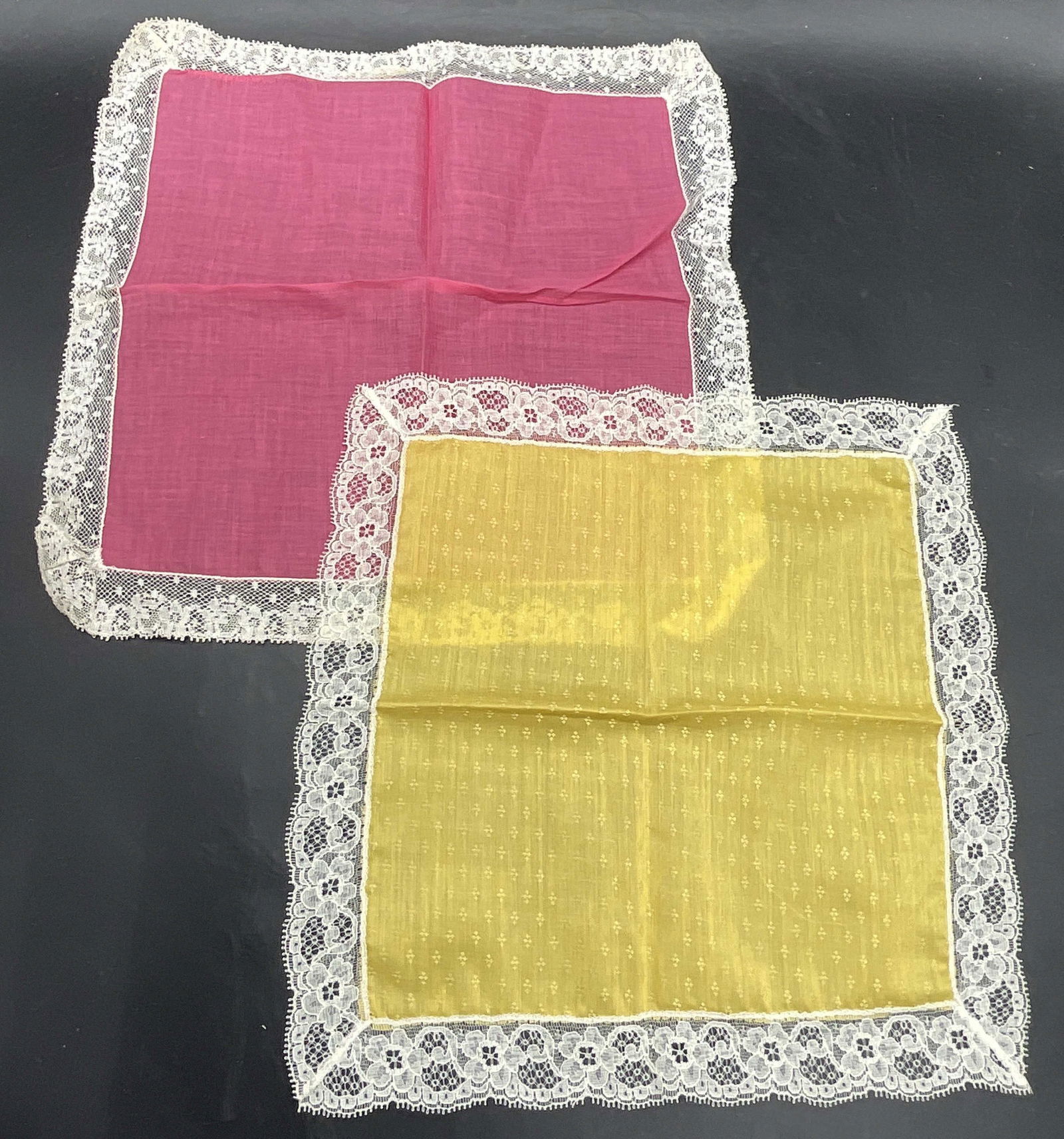 2 Vintage Pink & Yellow Lace Trim Handkerchiefs: Two Vintage Pink & Yellow Lace Trim Handkerchiefs. Crafted from soft hand material. Measures approx. 11.25L x 11.25W in. Surface wear, discoloration, and residue present. Accessories, wearables, vinta
