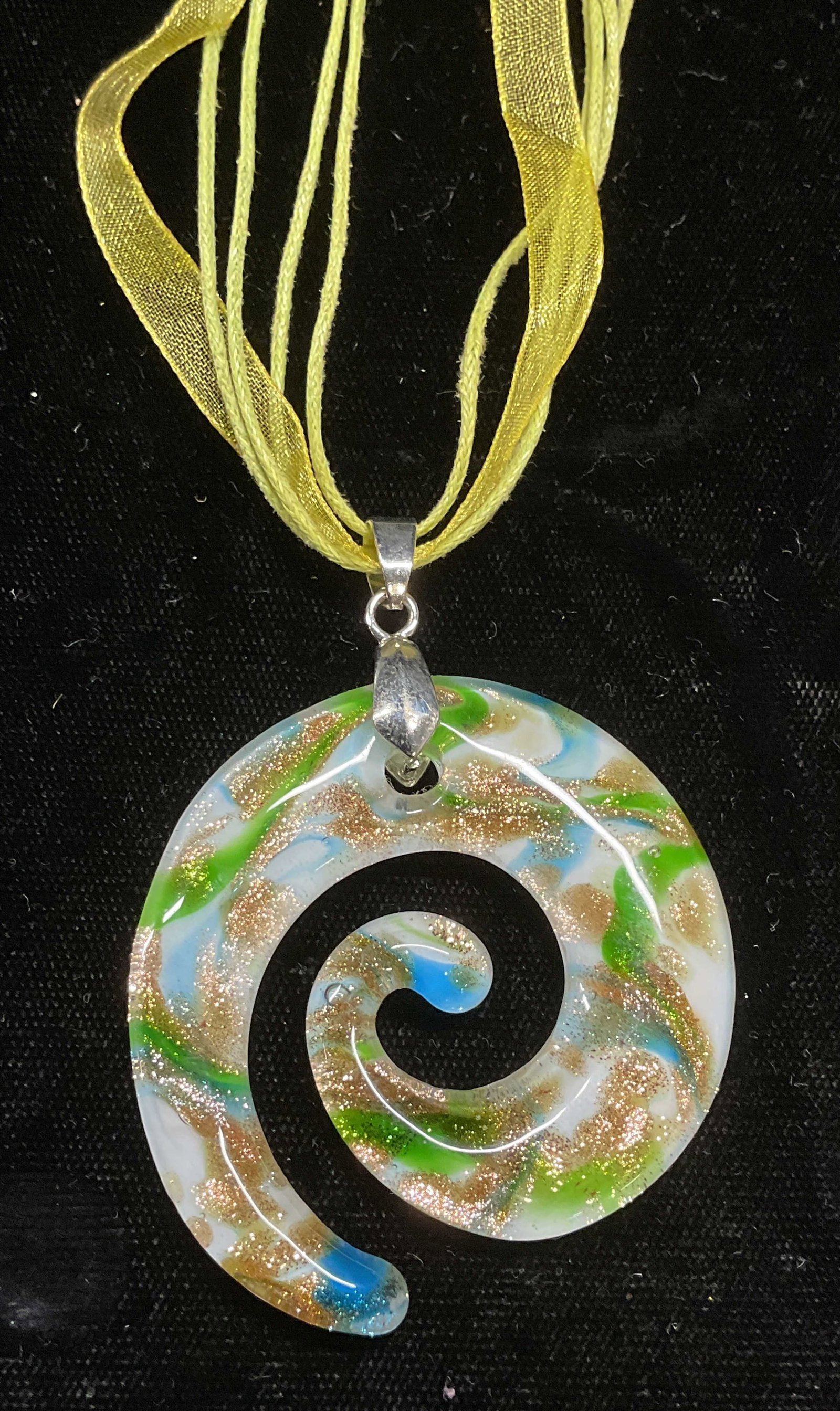 Green & Gold Art Glass Swirl Pendant Necklace: Multi strand ribbon necklace with art glass swirl pendant in white, green, gold, and blue. Drop length approx 9 inches. Pendant measures approx 2 inches long. Some wear including scratching observed. 